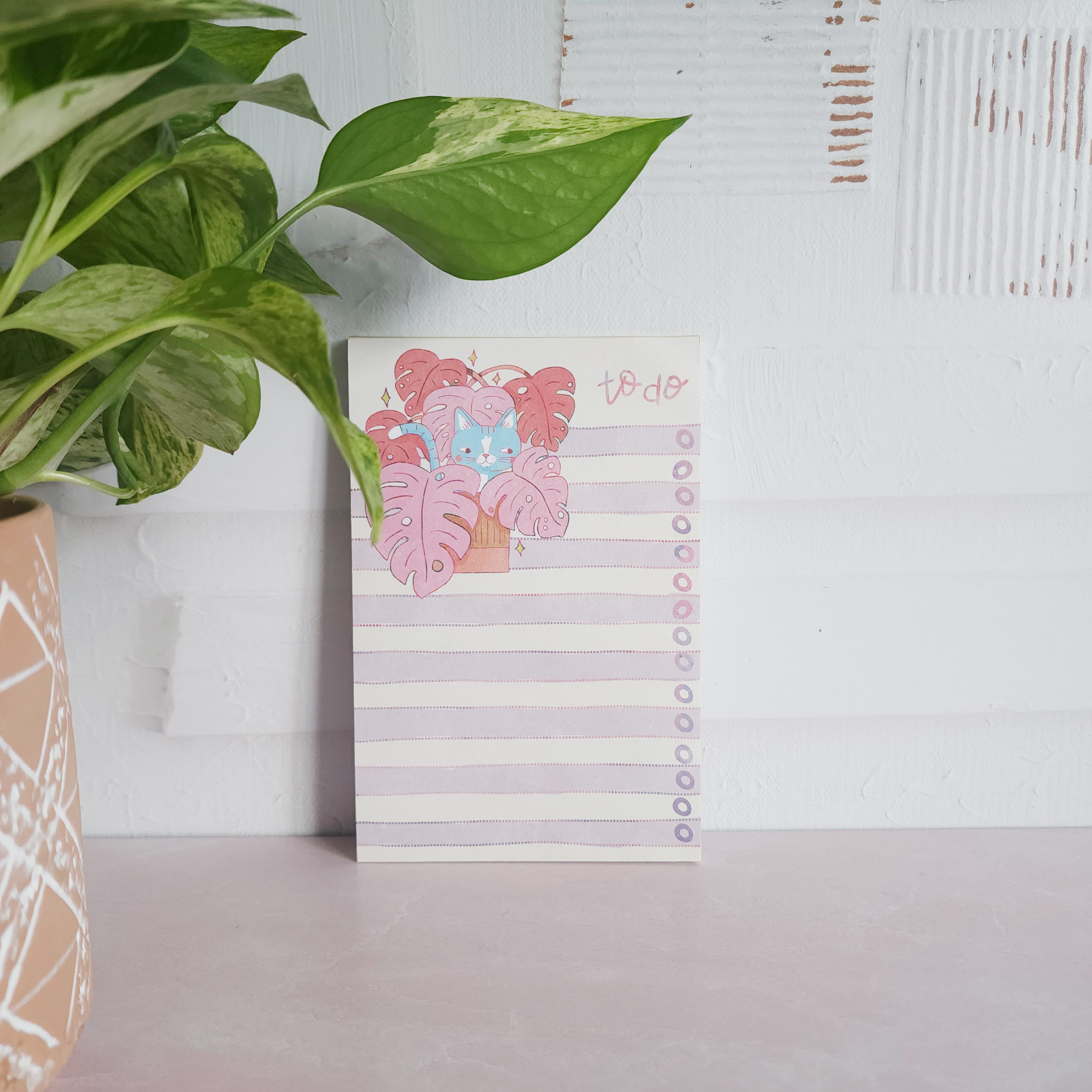 cat notepad leaning against a wall