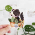 sticker of a black and white dog sitting in front of potted plants