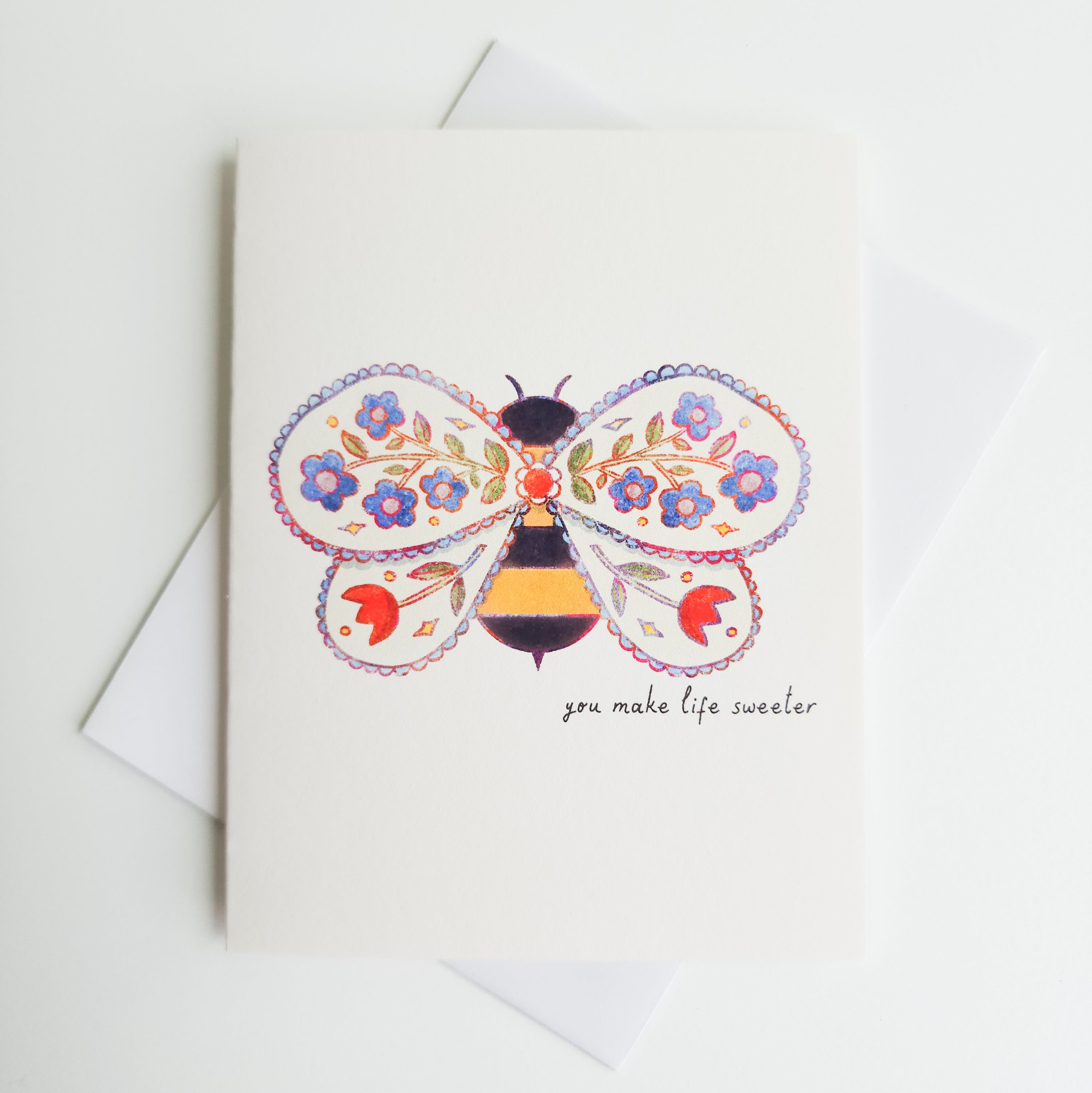 image of an illustrated bee with flowers inside of the wings