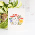 Card with floral design and a rabbit on a white background with plants in the background