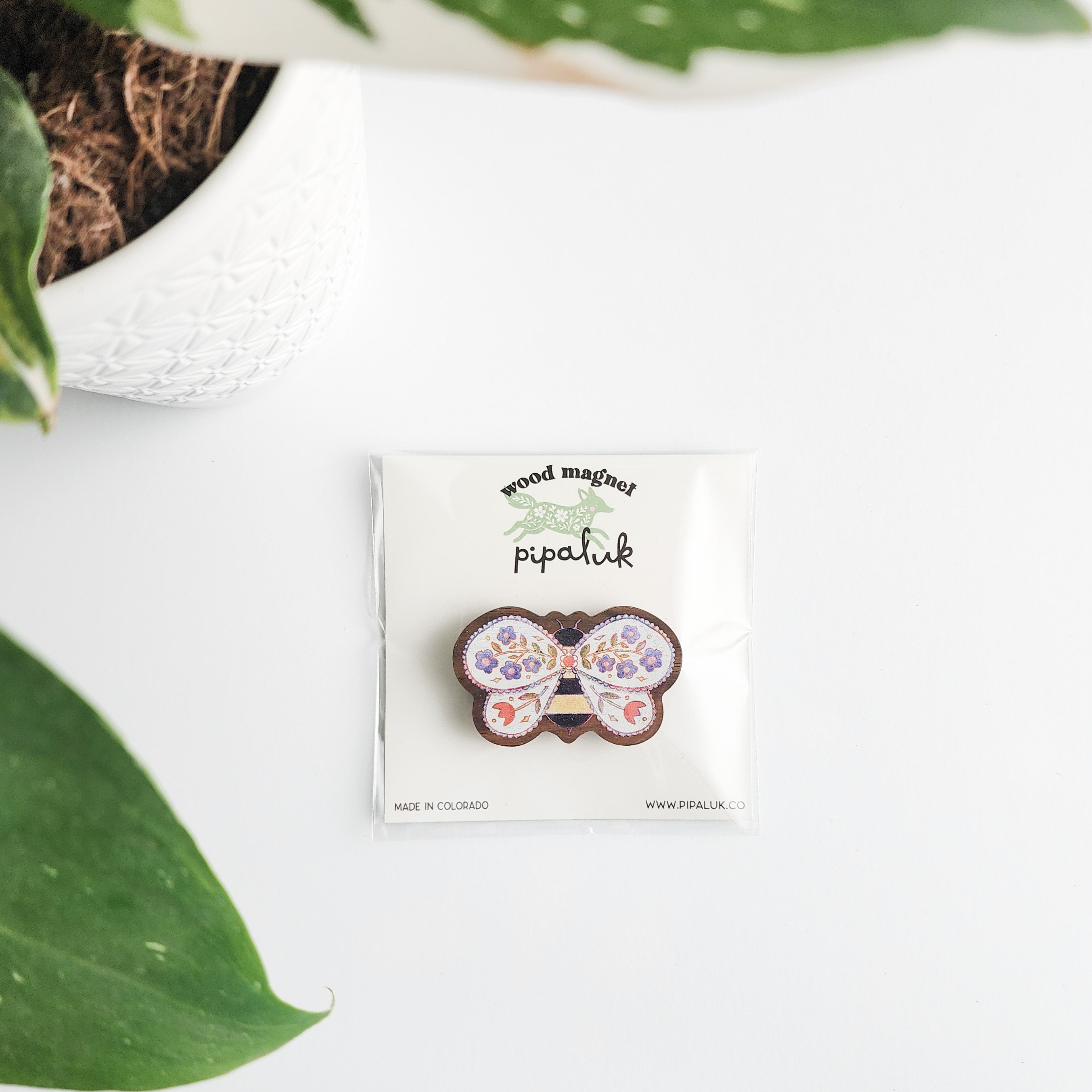 floral bee magnet in pipaluk packaging on a white background with leaves