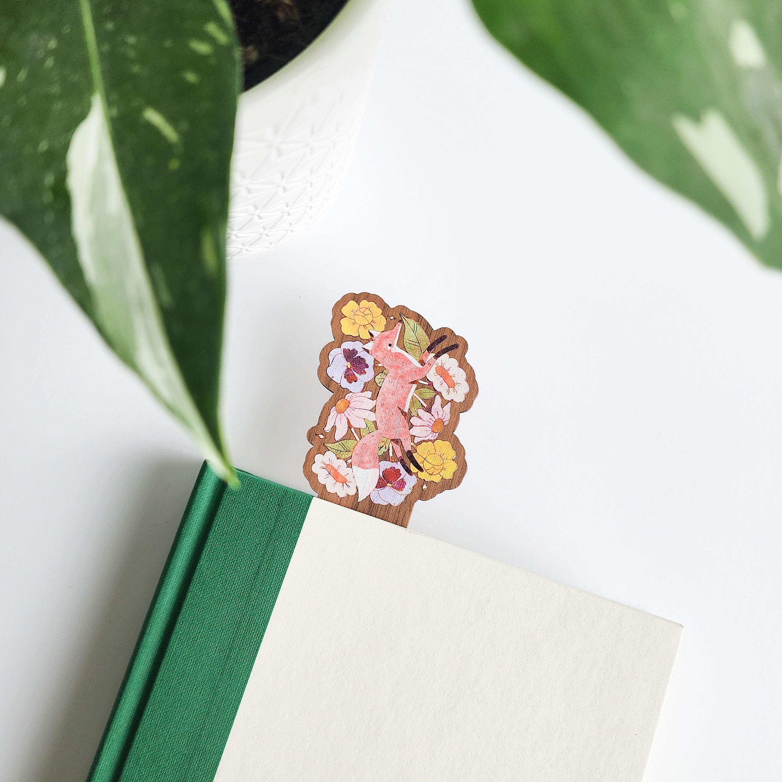 floral fox bookmark inside of a book on a white background