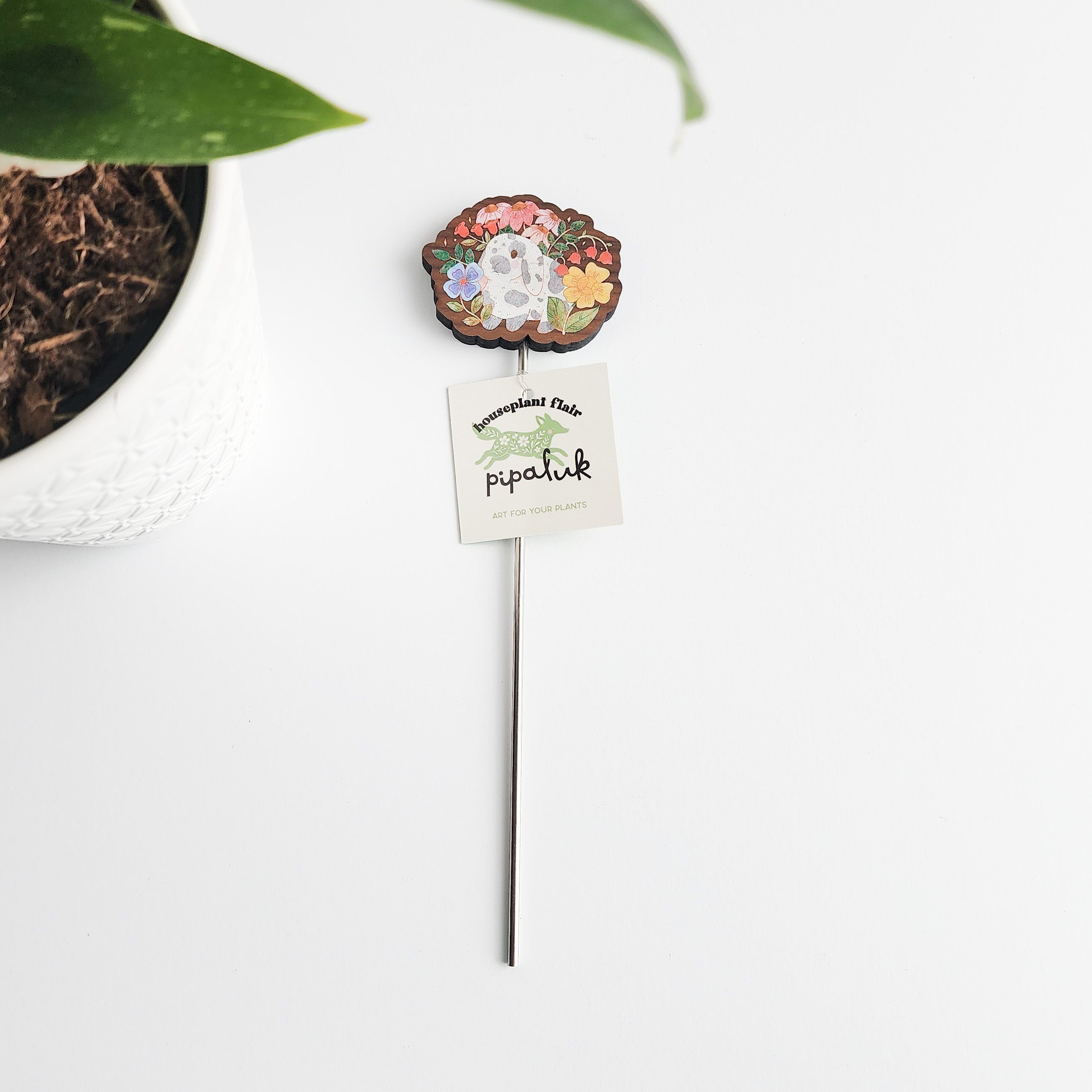 decorative floral bunny plant pick with a pipaluk label on a white background