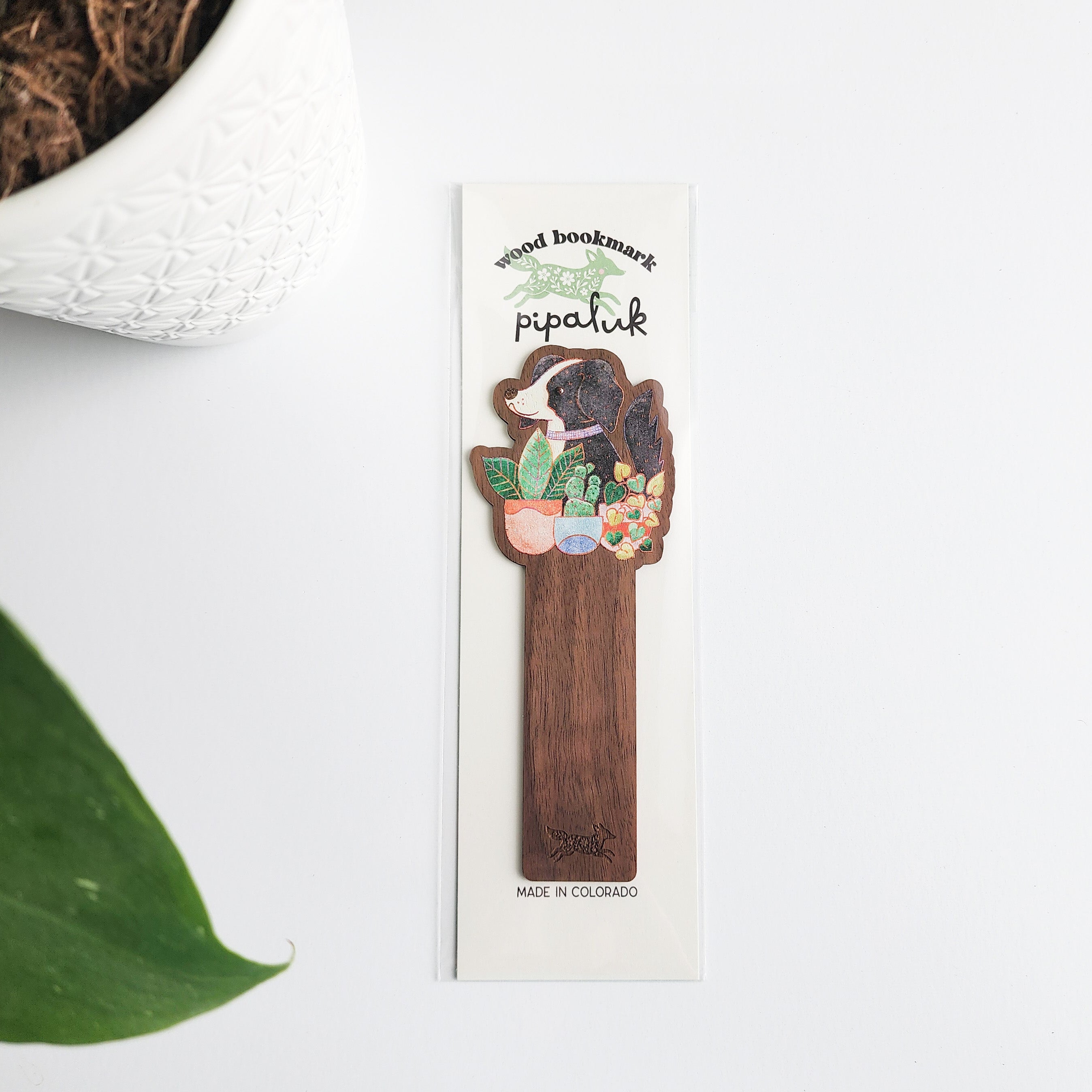 dog and houseplants bookmark in pipaluk packaging on a white background with leaves