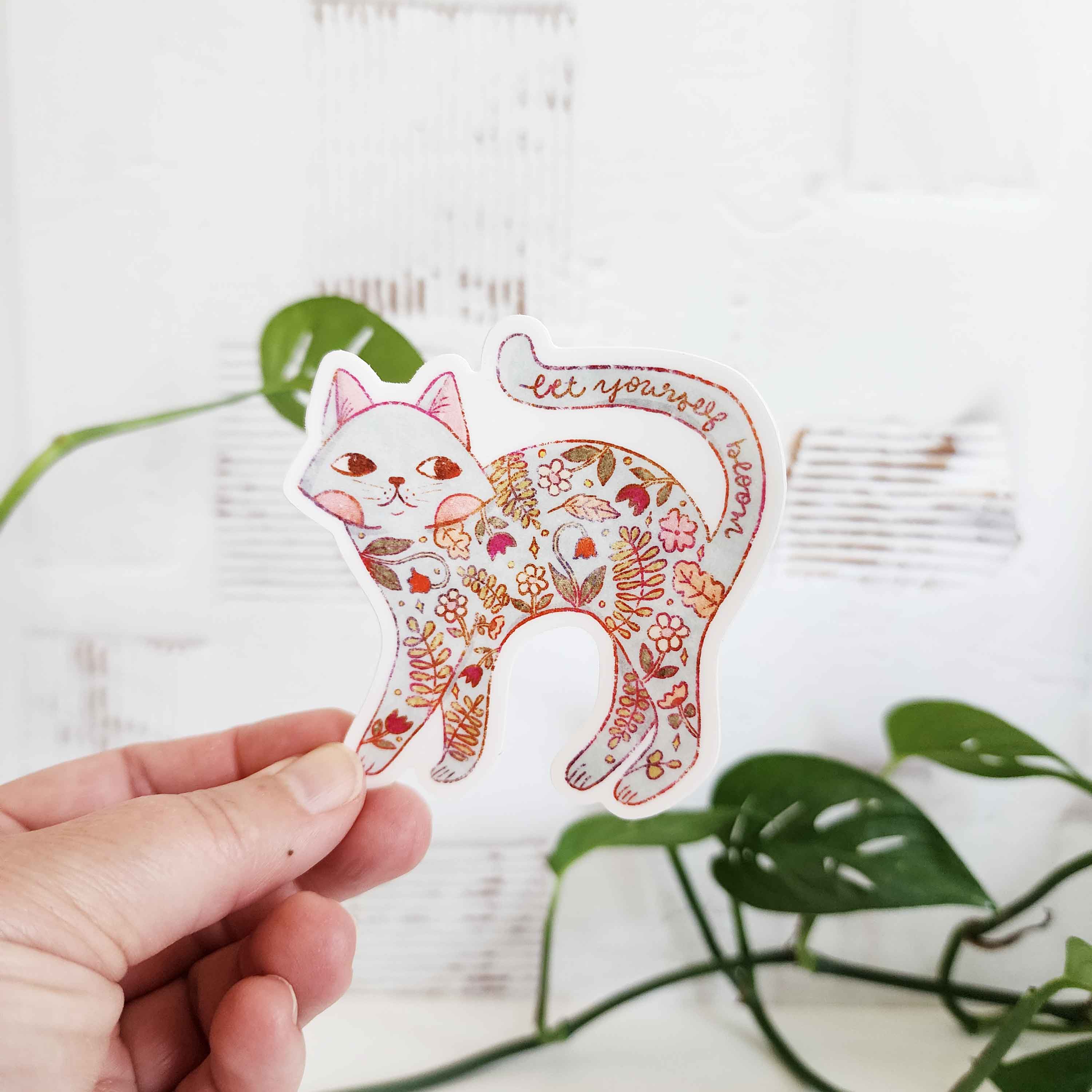 sticker of a cat filled with flowers and the words let yourself bloom