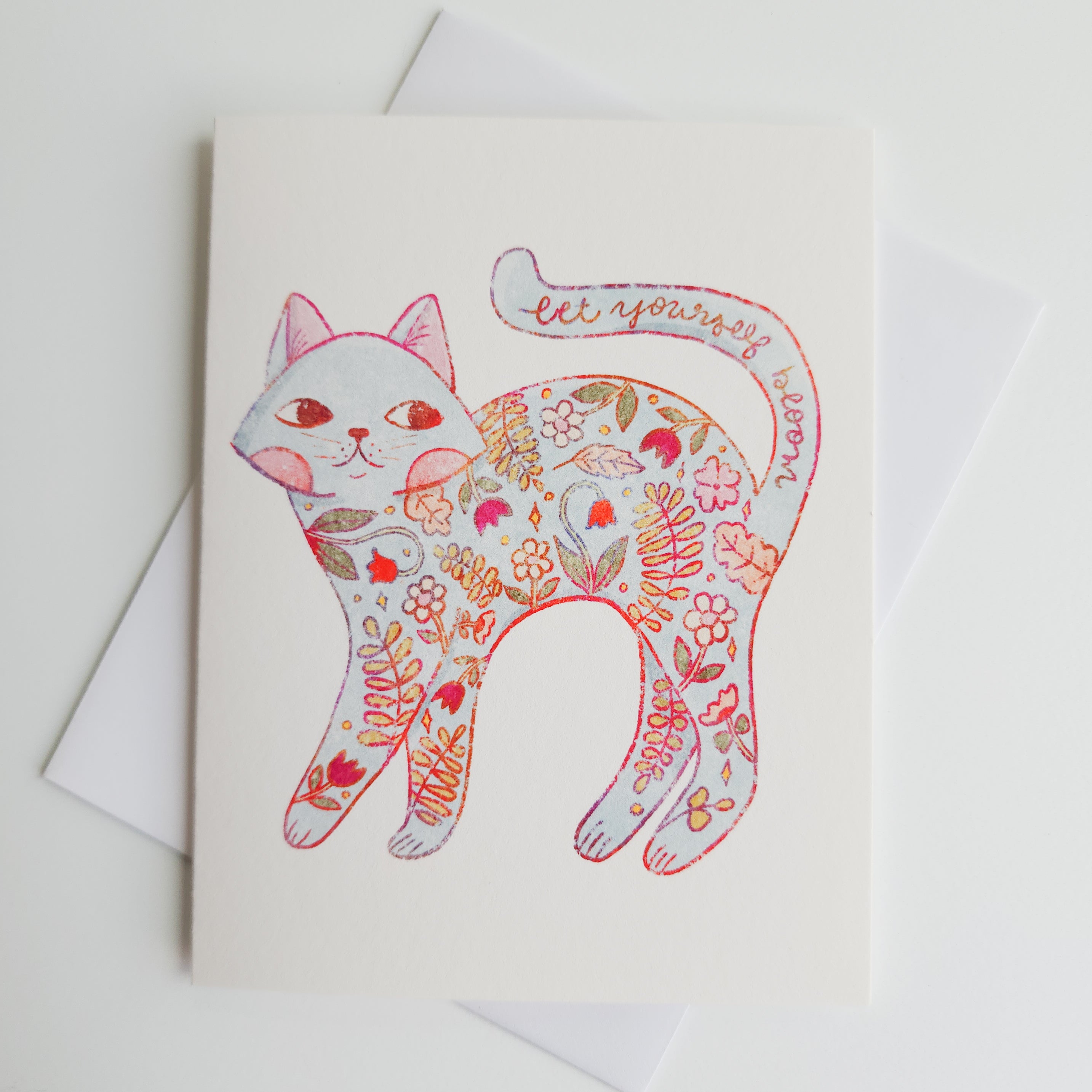 greeting card with the image of a floral cat with the words let yourself bloom along the tail
