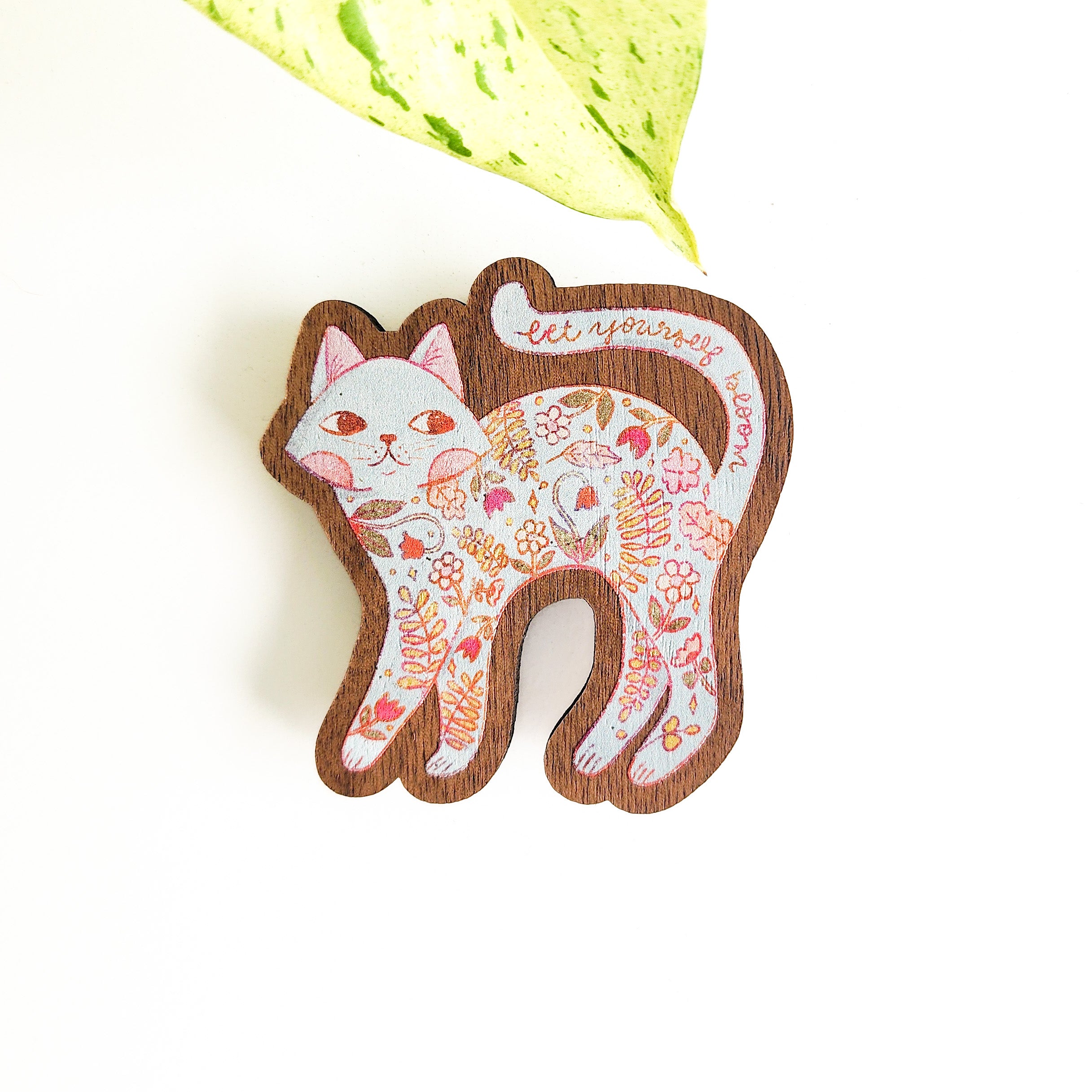 floral cat magnet on a white background with a leaf