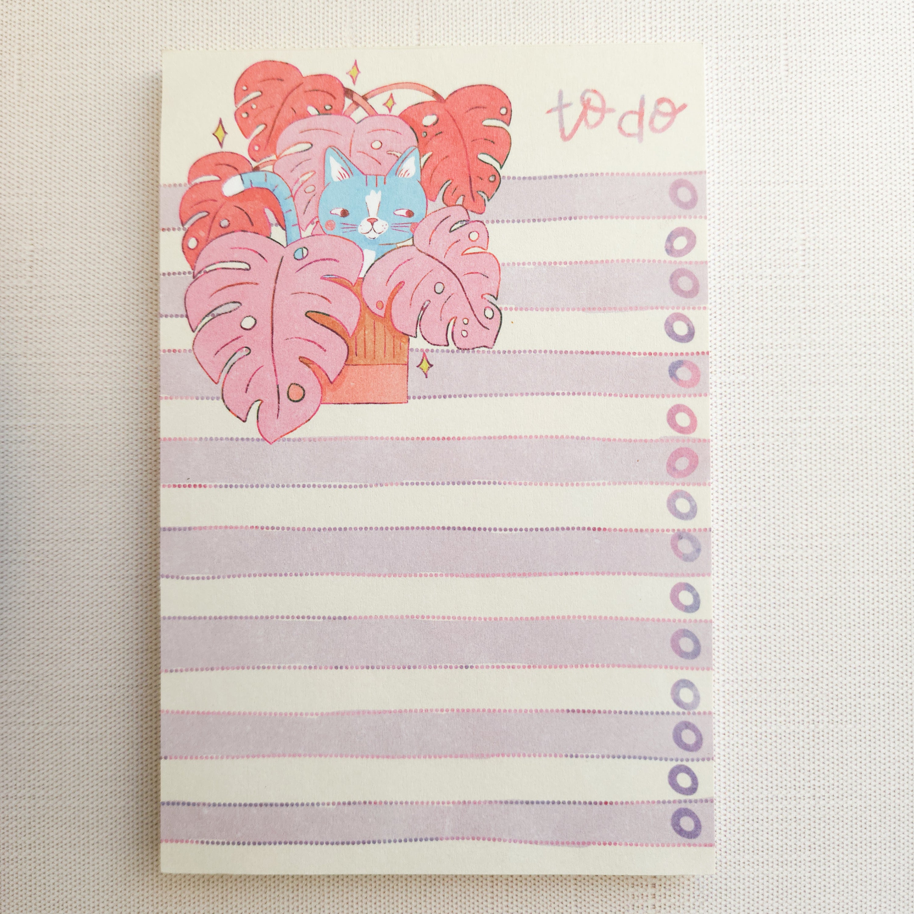 notepad with a cat in a monstera illustration on a white background