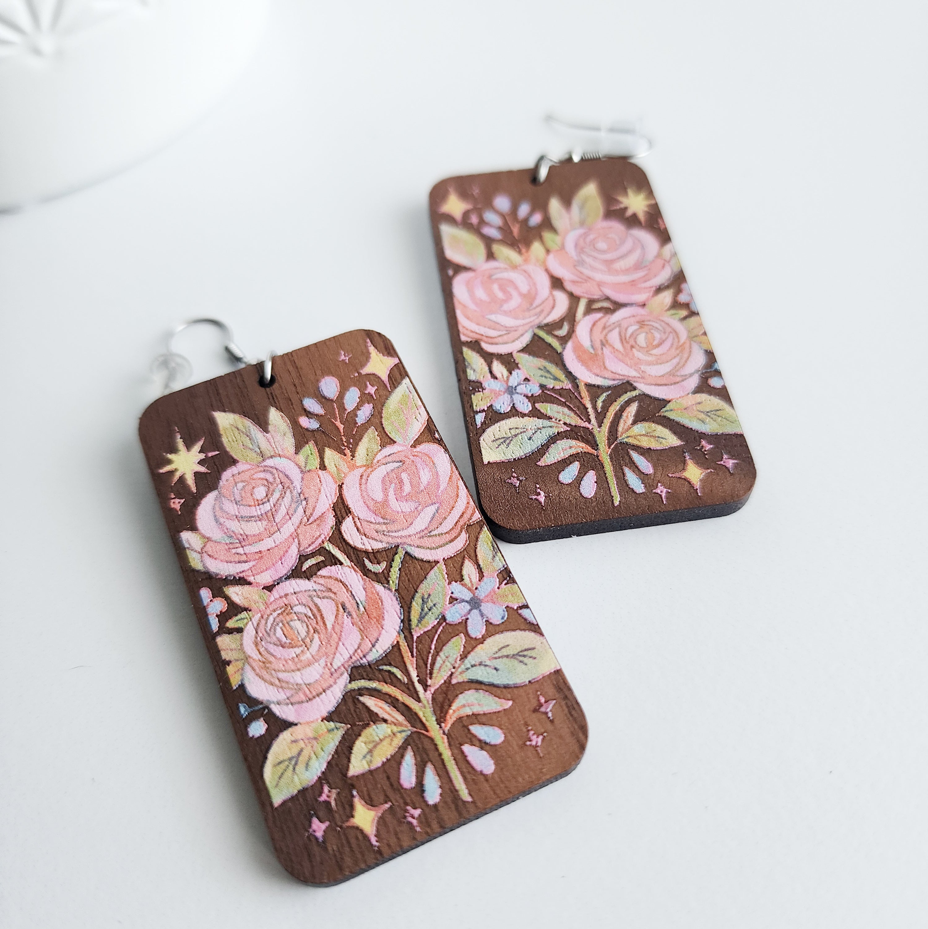 close up of rose bouquet earrings on a white background