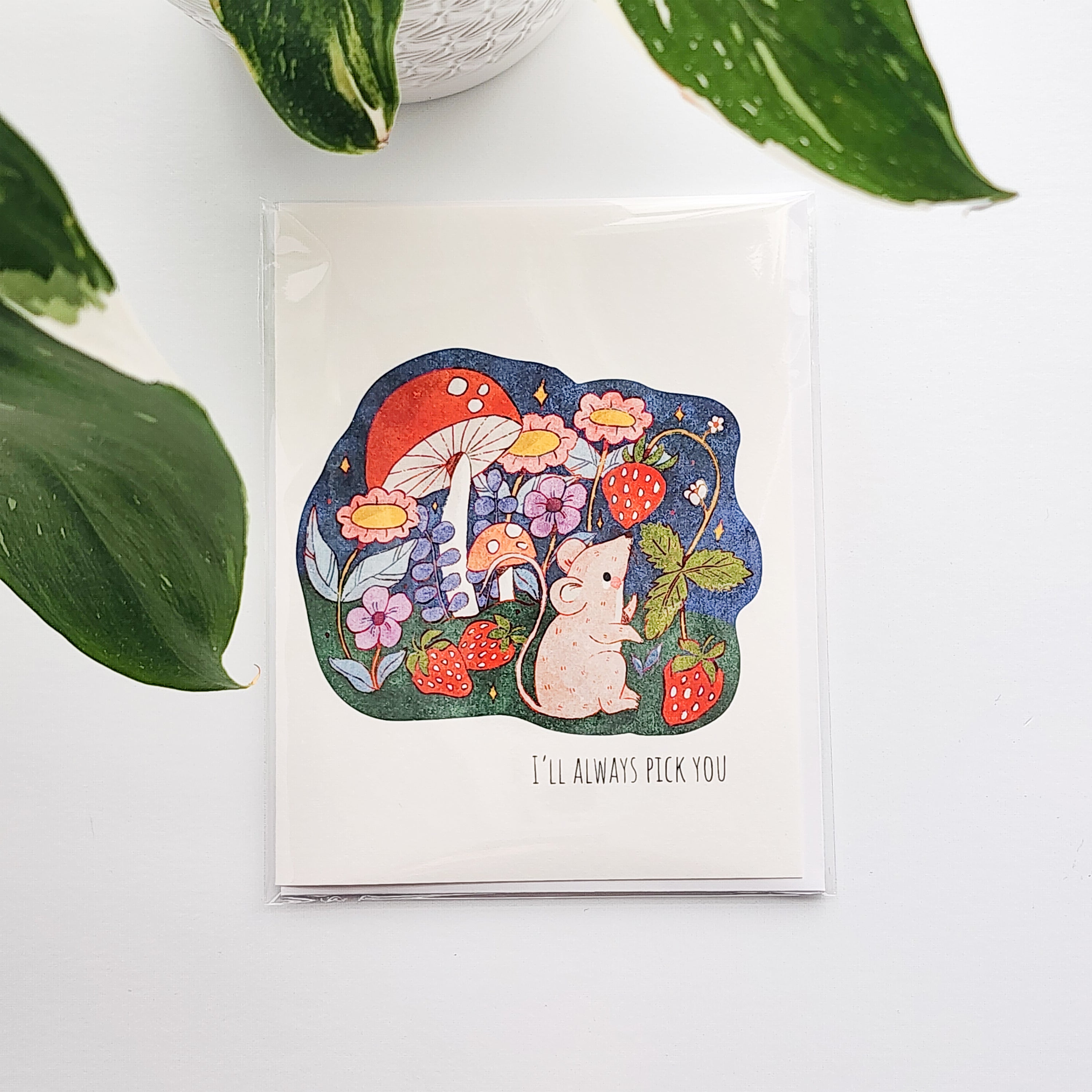 Greeting card with a mouse and strawberry design on a white background with green leaves.