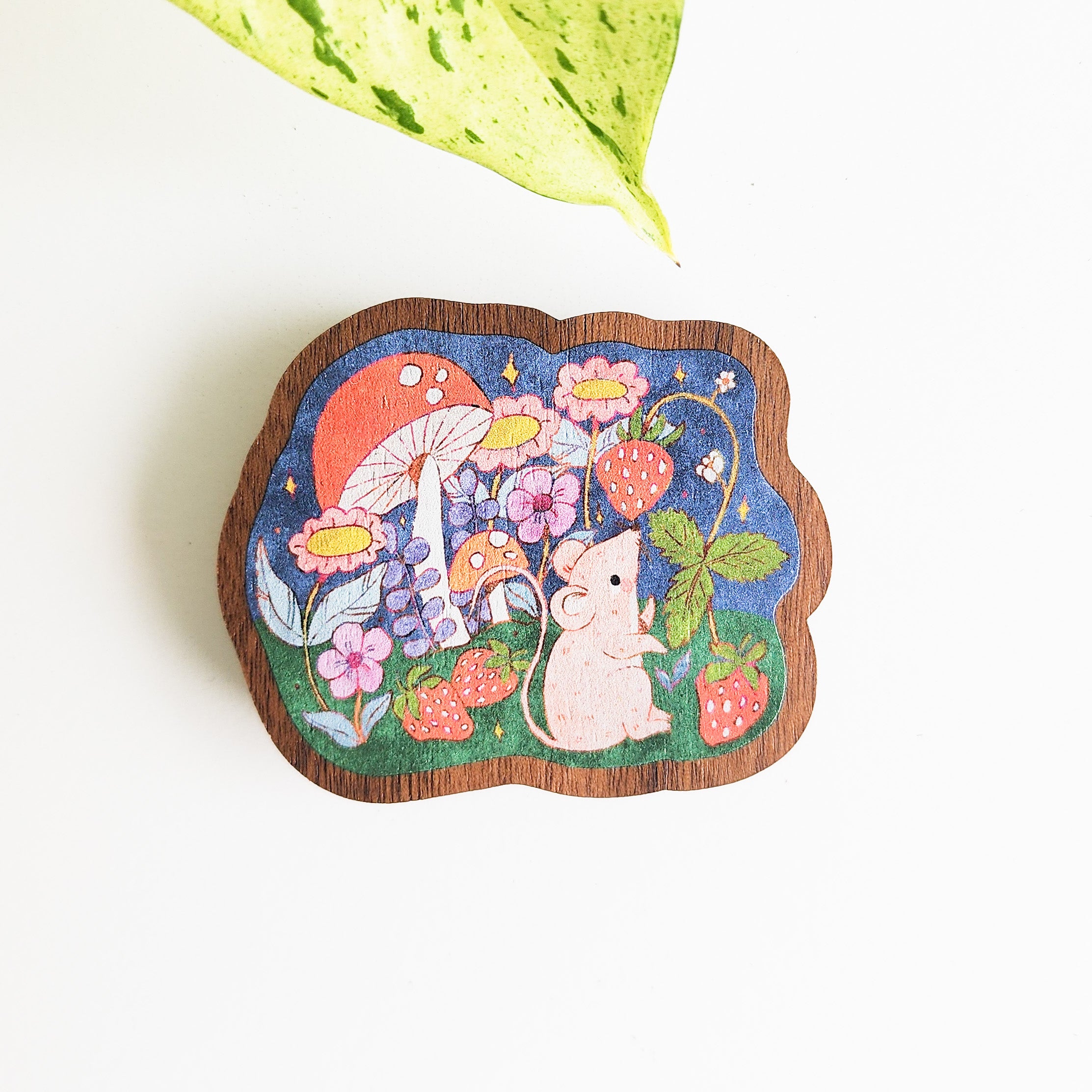 magnet with a mouse picking strawberries on a white background with a leaf