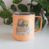 orange turtle mug in front of a plant