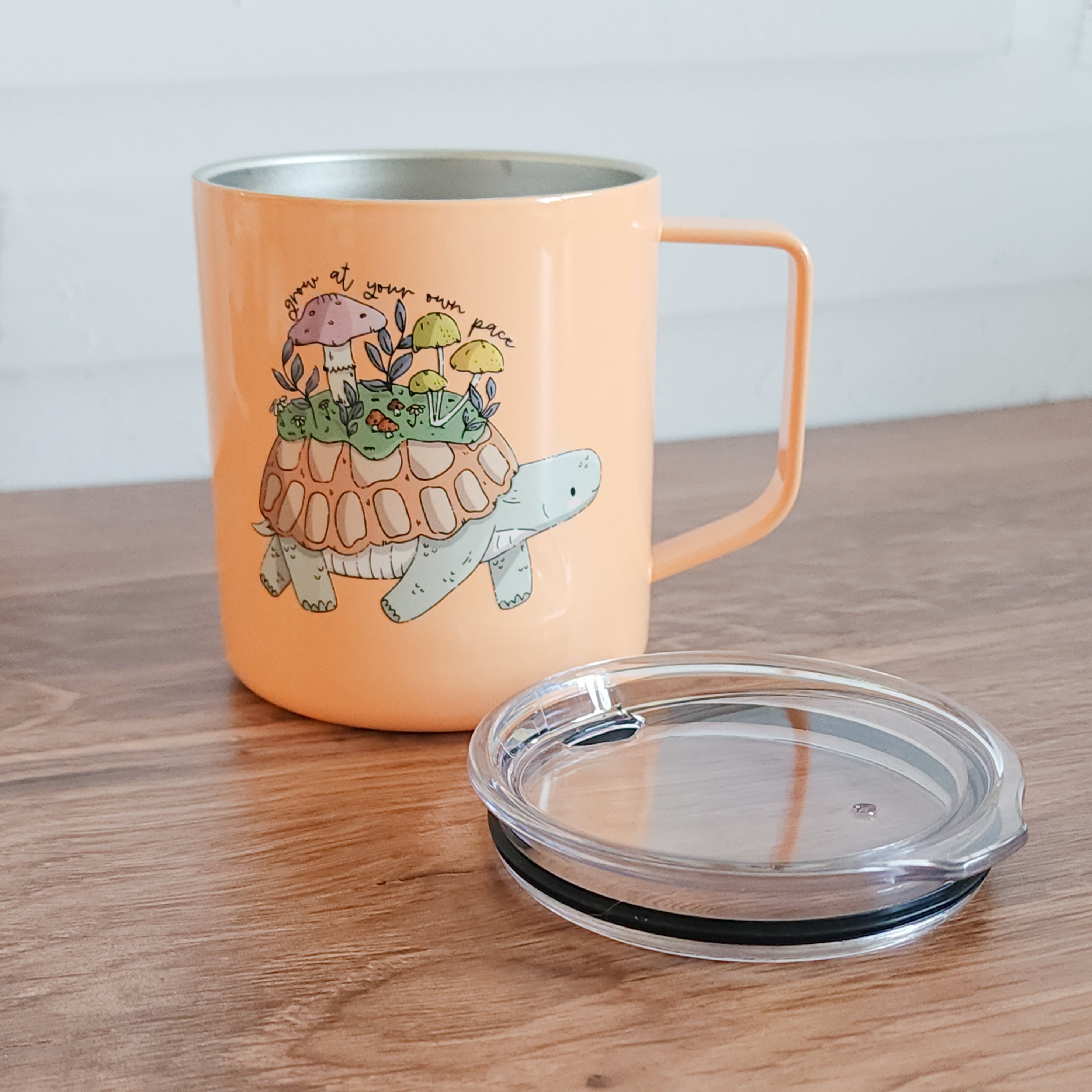 orange turtle mug with lid sitting in front