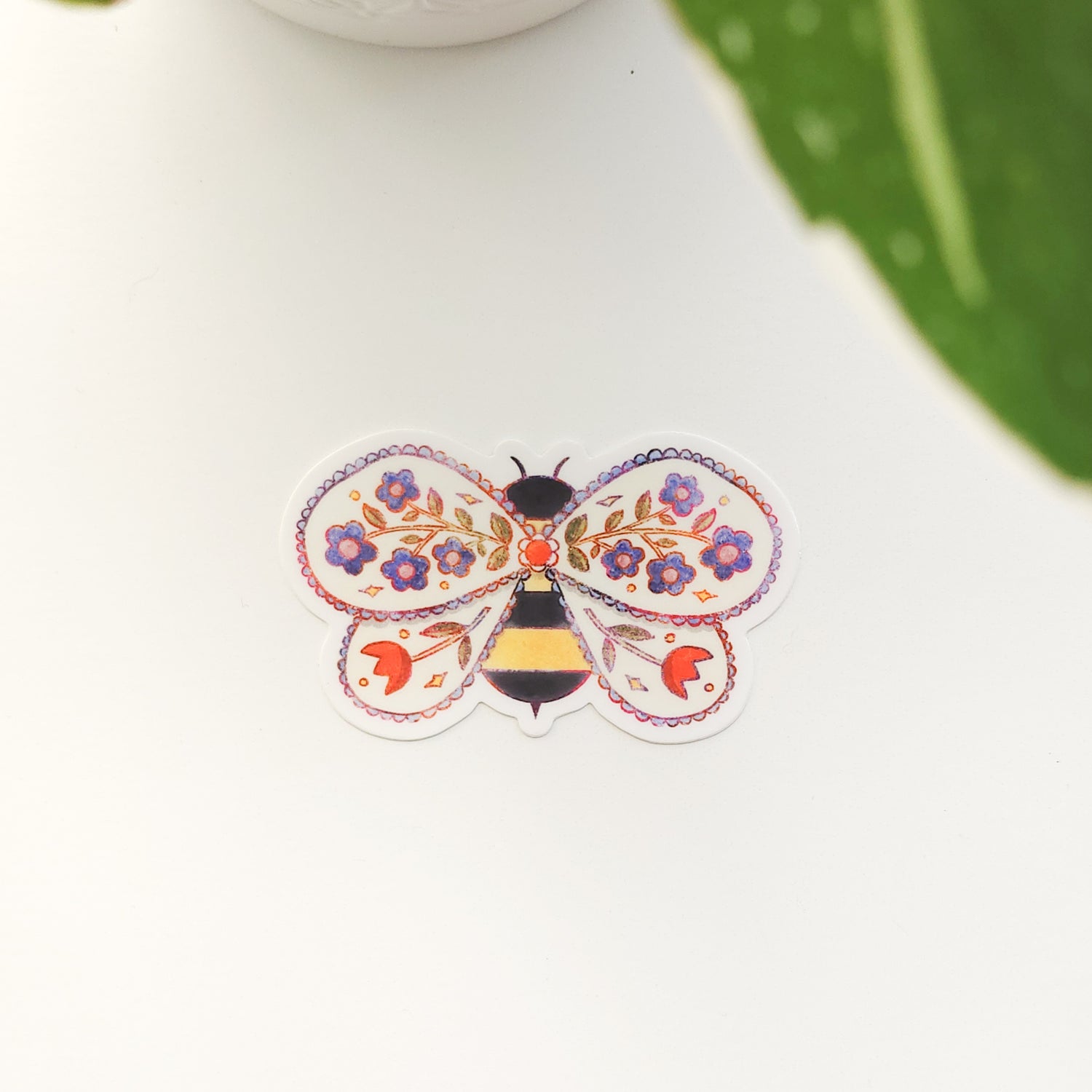 Decorative sticker of a bee with floral elements on a white background