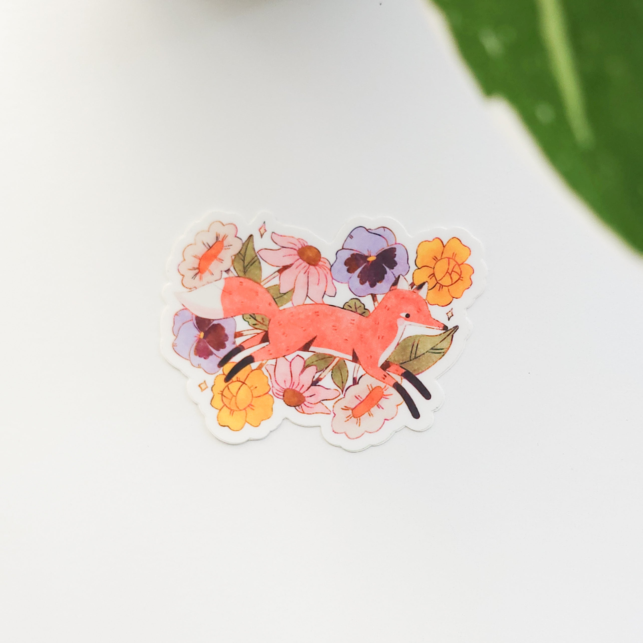 Sticker of a fox among flowers on a white background