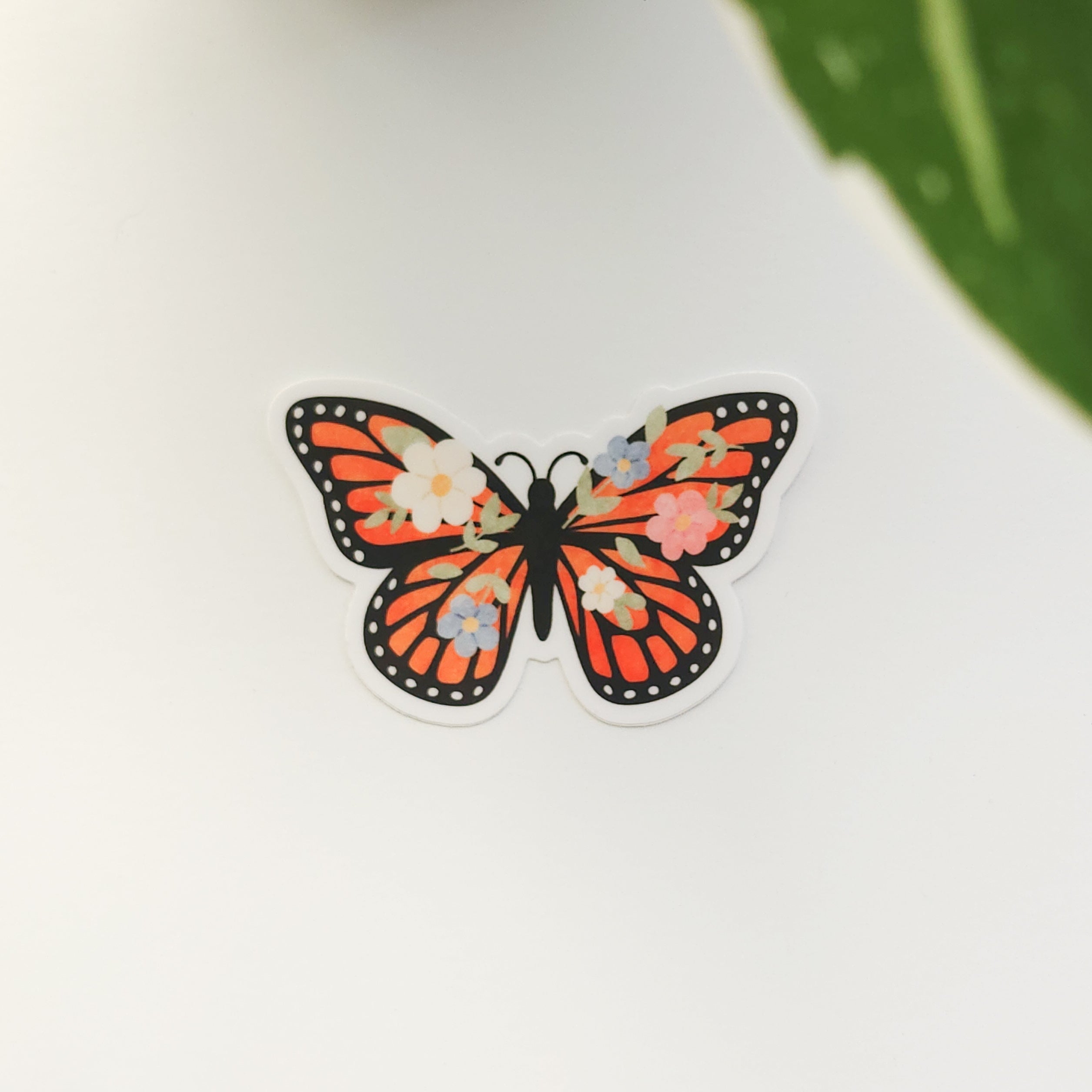 Butterfly-shaped sticker with floral design on a white background
