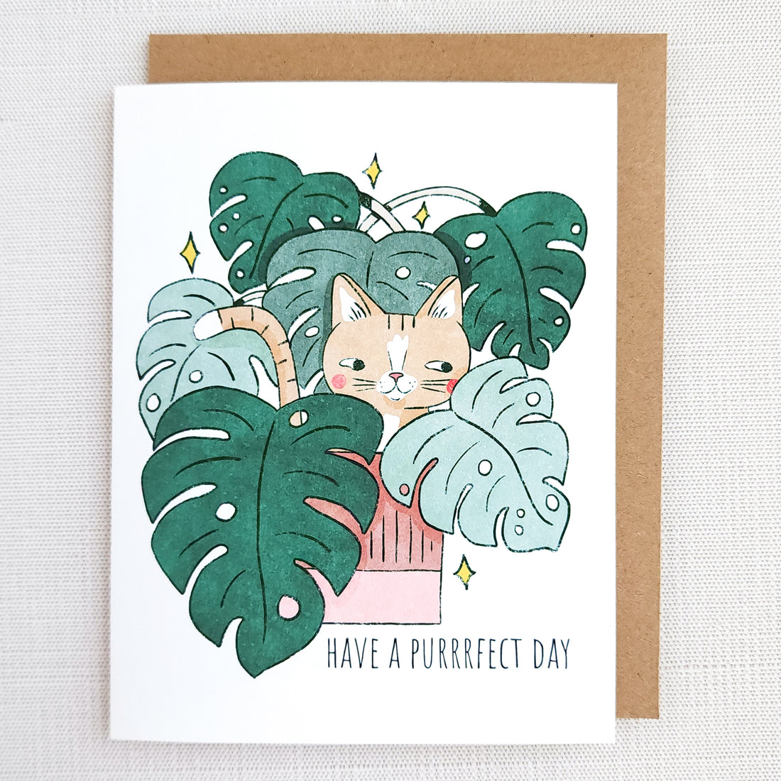 Greeting card with a cat illustration and leaf design, featuring the text &