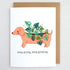 Card with a dachshund illustration holding a plant, text &