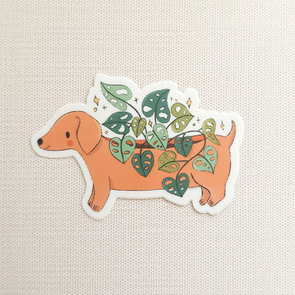 sticker with an illustration of a dachshund planter with a cheese plant on a linen background
