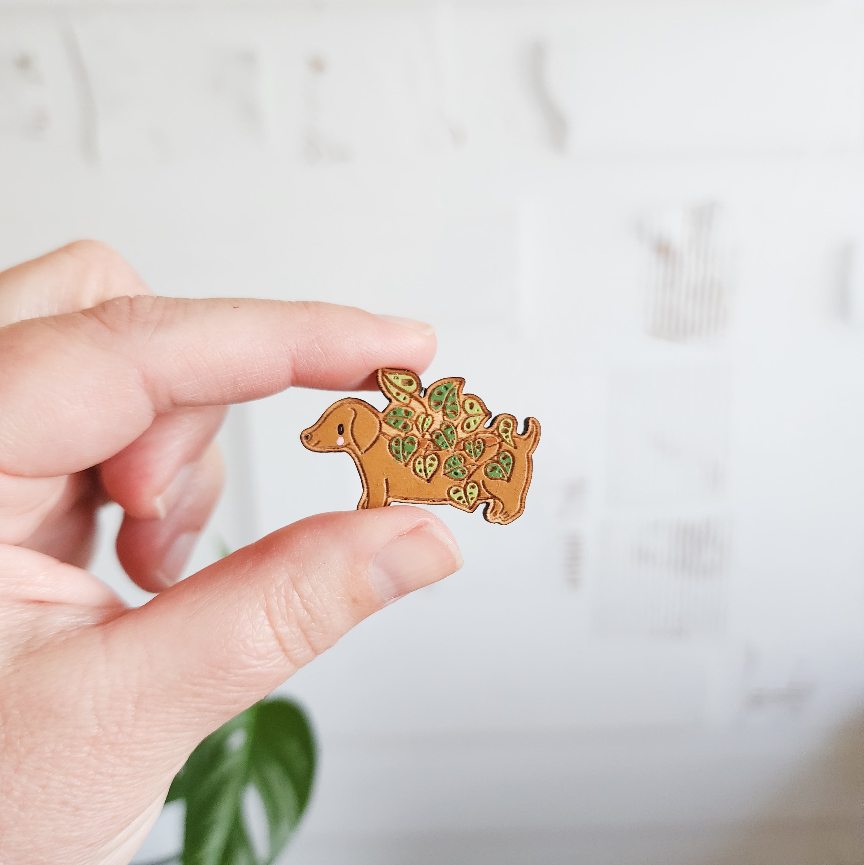 dachshund planter pin held between two fingers