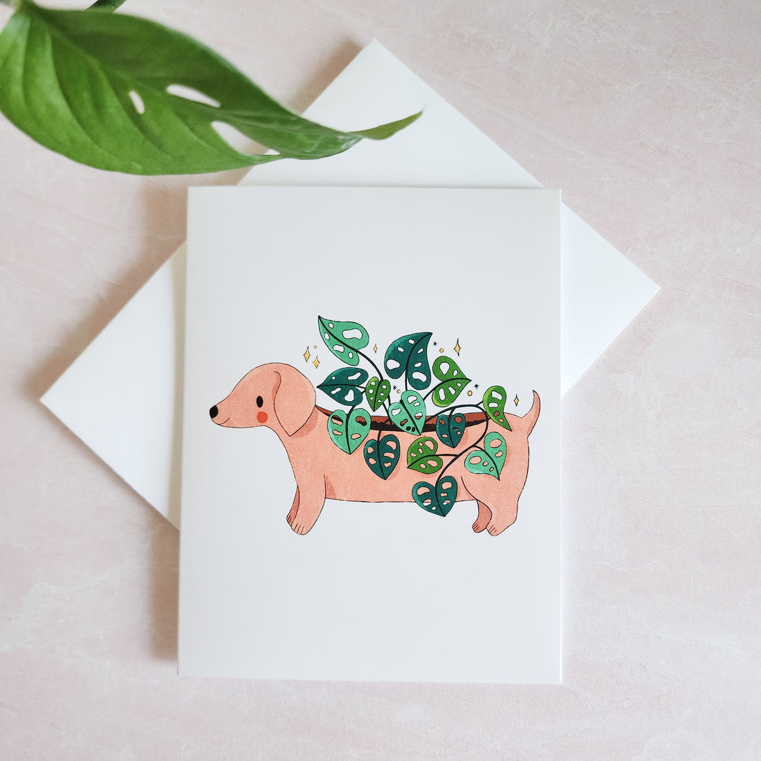 greeting card with an illustrated dachshund planter with a plant growing out of its back
