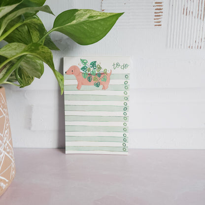 dachshund planter to do list leaning against a wall