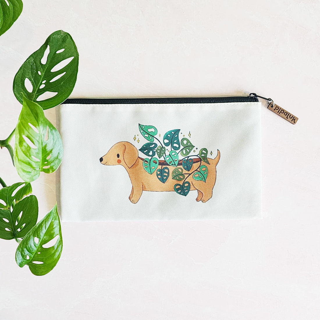zipper pouch with a dachshund planter growing a cheese plant