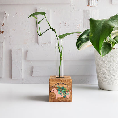 dachshund wooden propagation station with a wooden block and glass tube with a green plant cutting on a white background