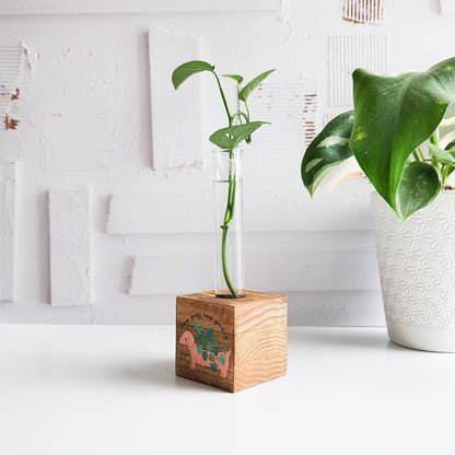 dachshund wooden propagation station with a wooden block and glass tube with a green plant cutting on a white background