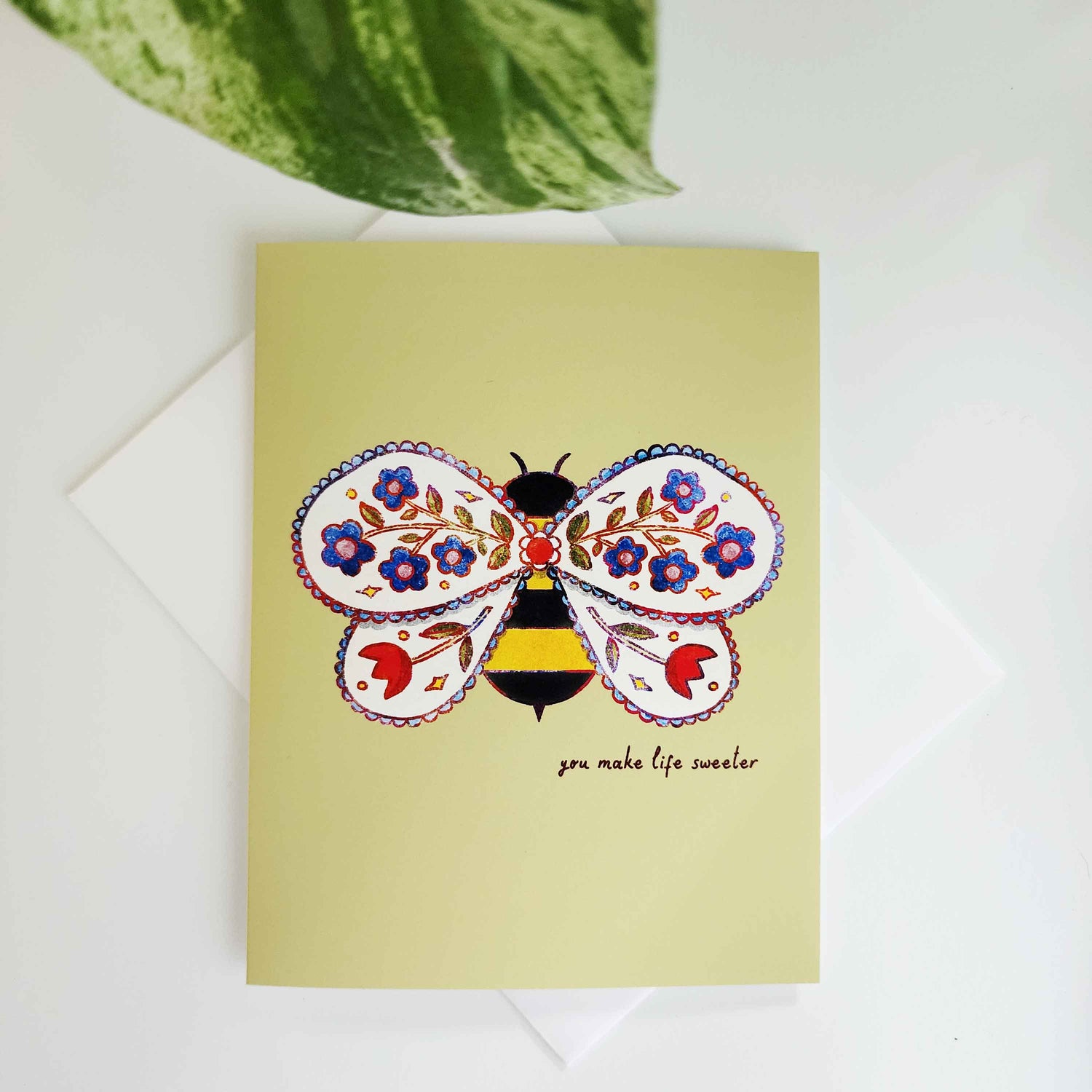 green greeting card with a bee with flowers in its wings and the words you make life sweeter