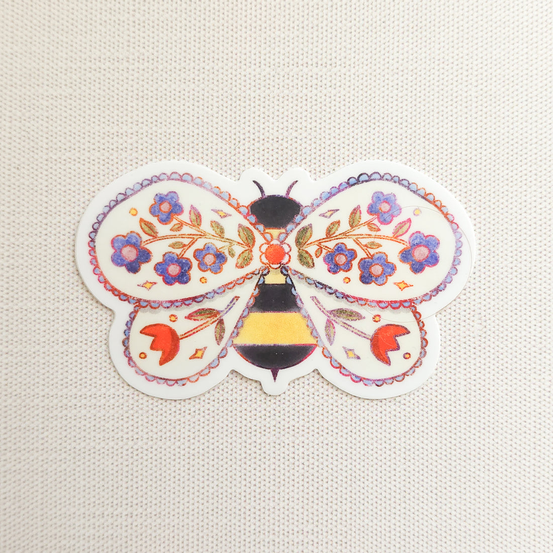 sticker of an illustrated bee with flowers in its wings