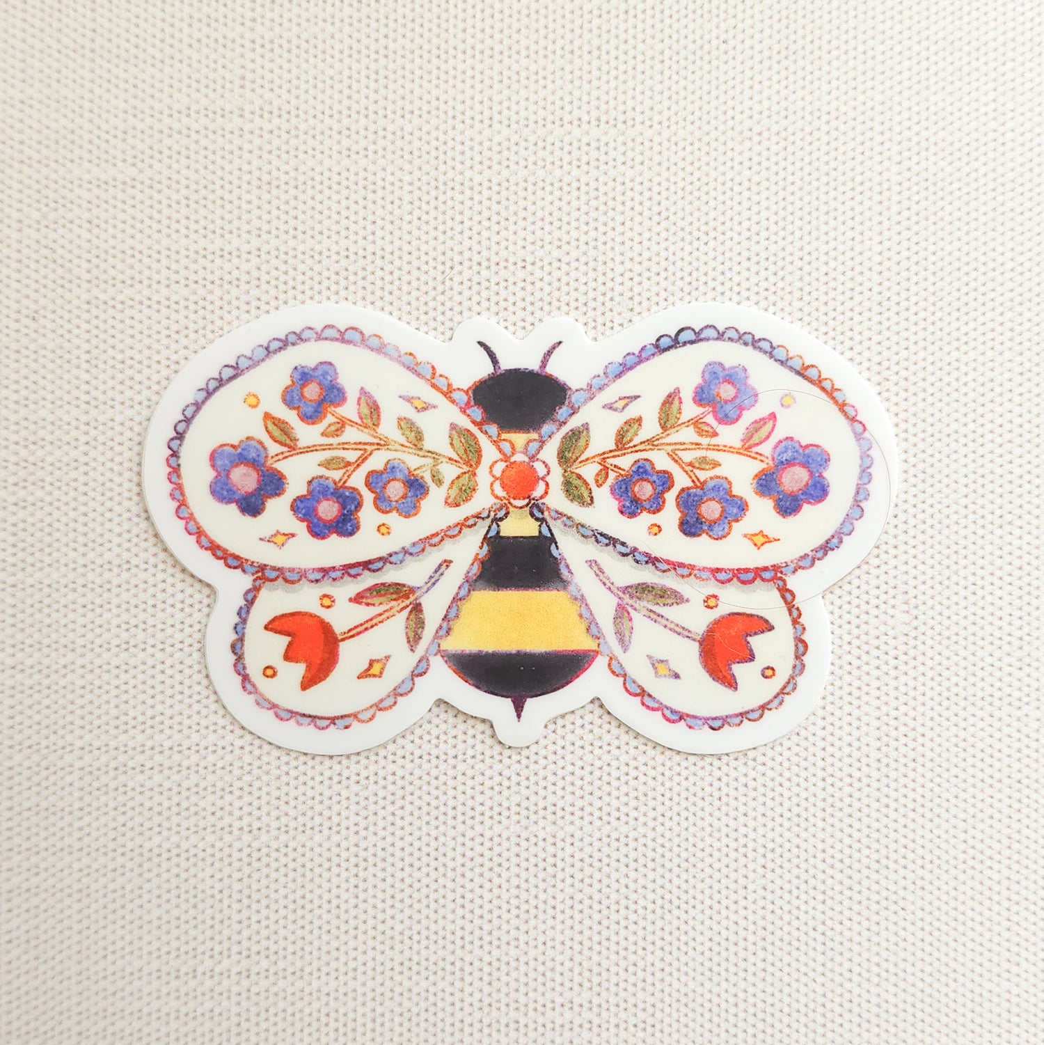 sticker of an illustrated bee with flowers in its wings