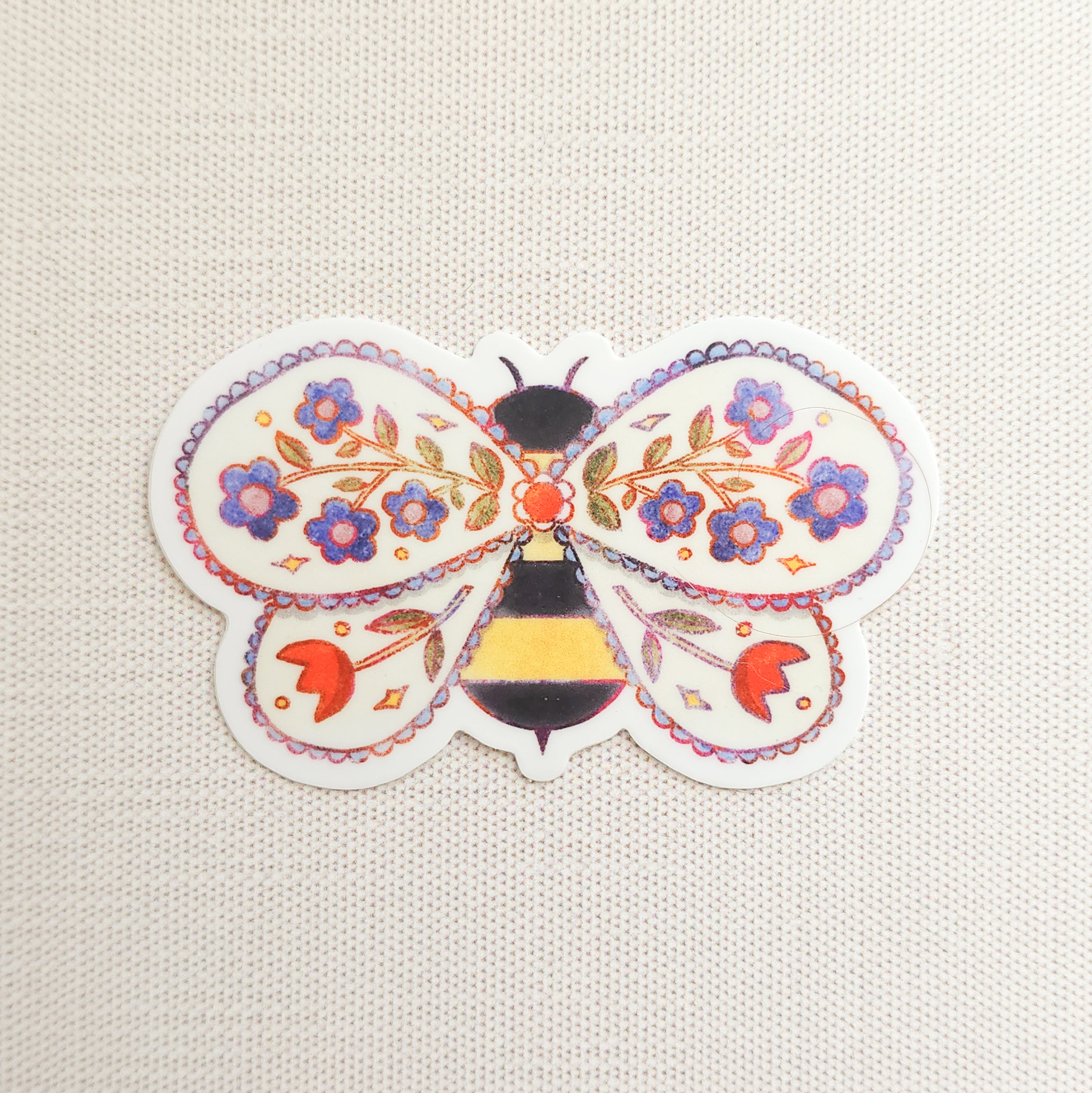 sticker of an illustrated bee with flowers in its wings