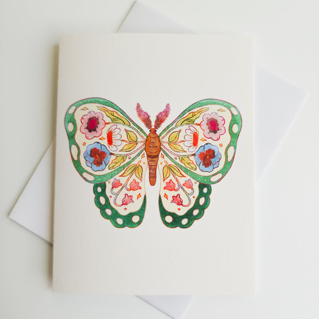 image of a greeting card with a green butterfly with flowers illustrated inside its wings