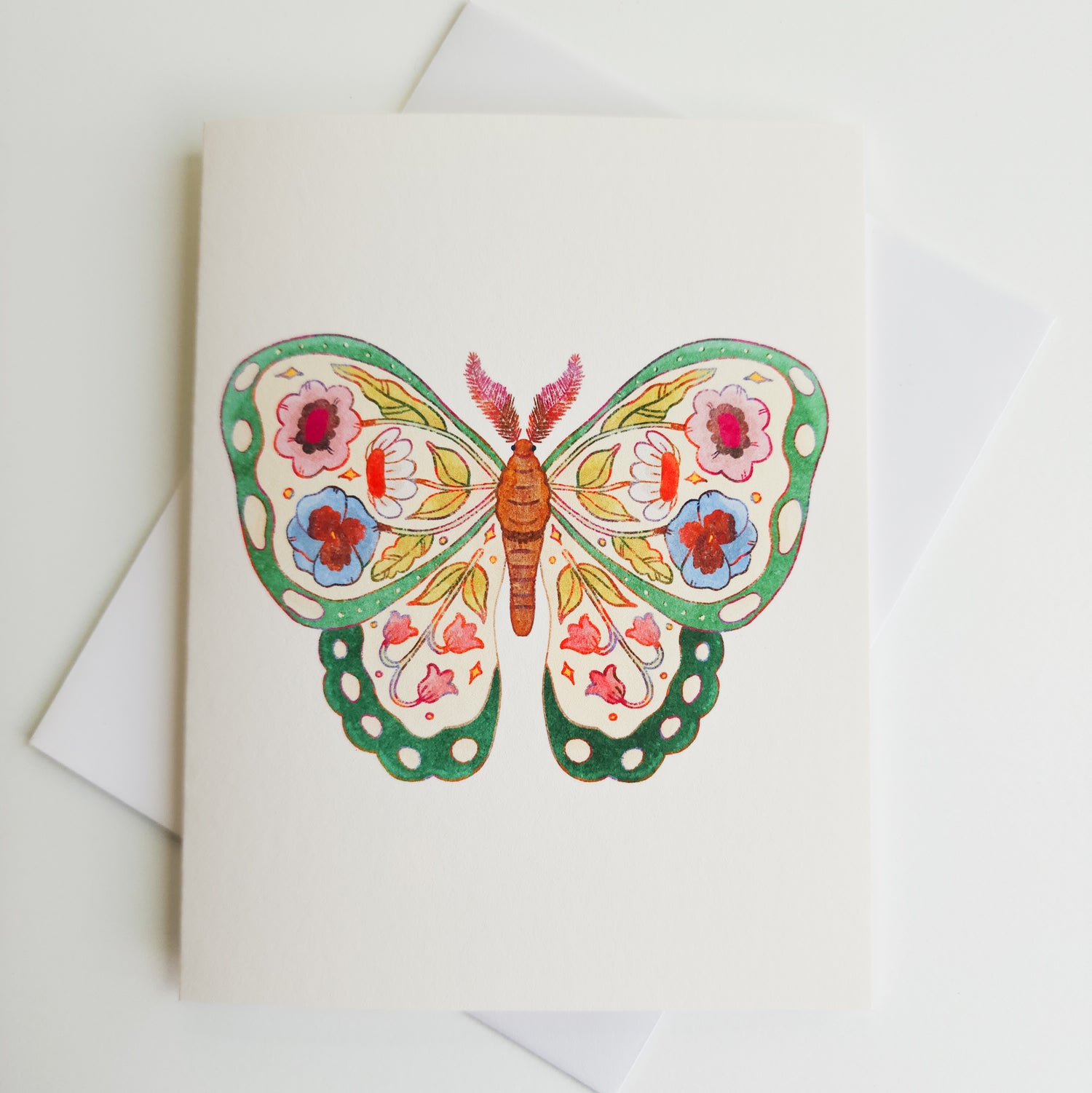 image of a greeting card with a green butterfly with flowers illustrated inside its wings