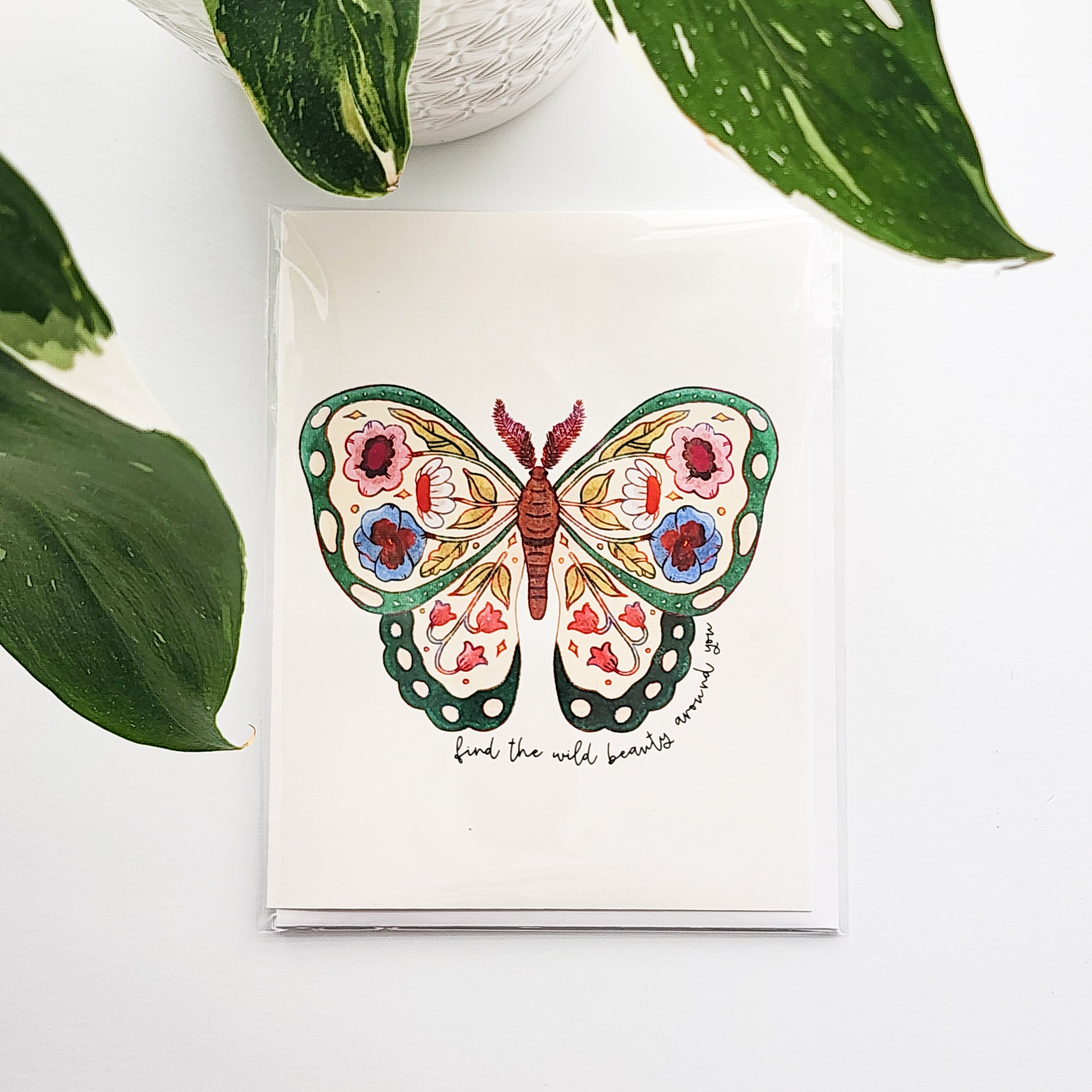 butterfly  card with floral design on a white background with green leaves.