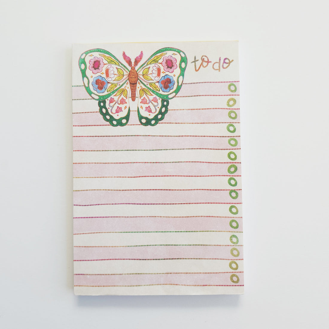 notepad with a colorful butterfly design on the cover, featuring the text &