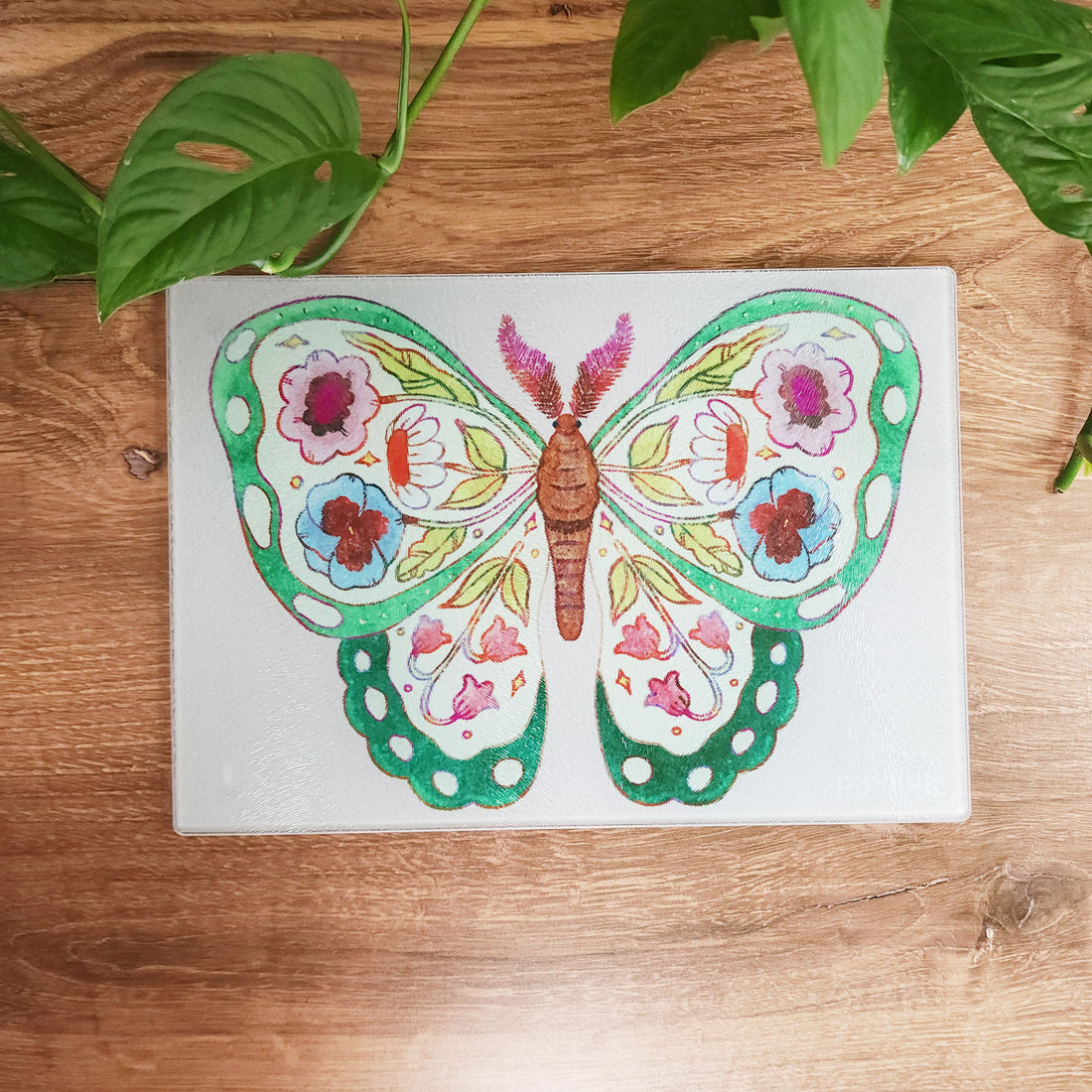 glass butterfly cutting board sitting on a wood table