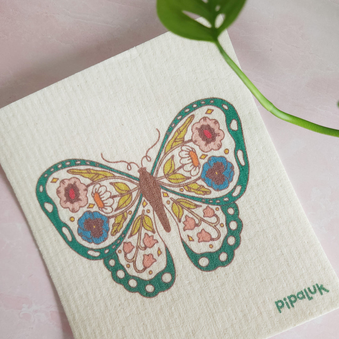 floral butterfly dishcloth against a pink background