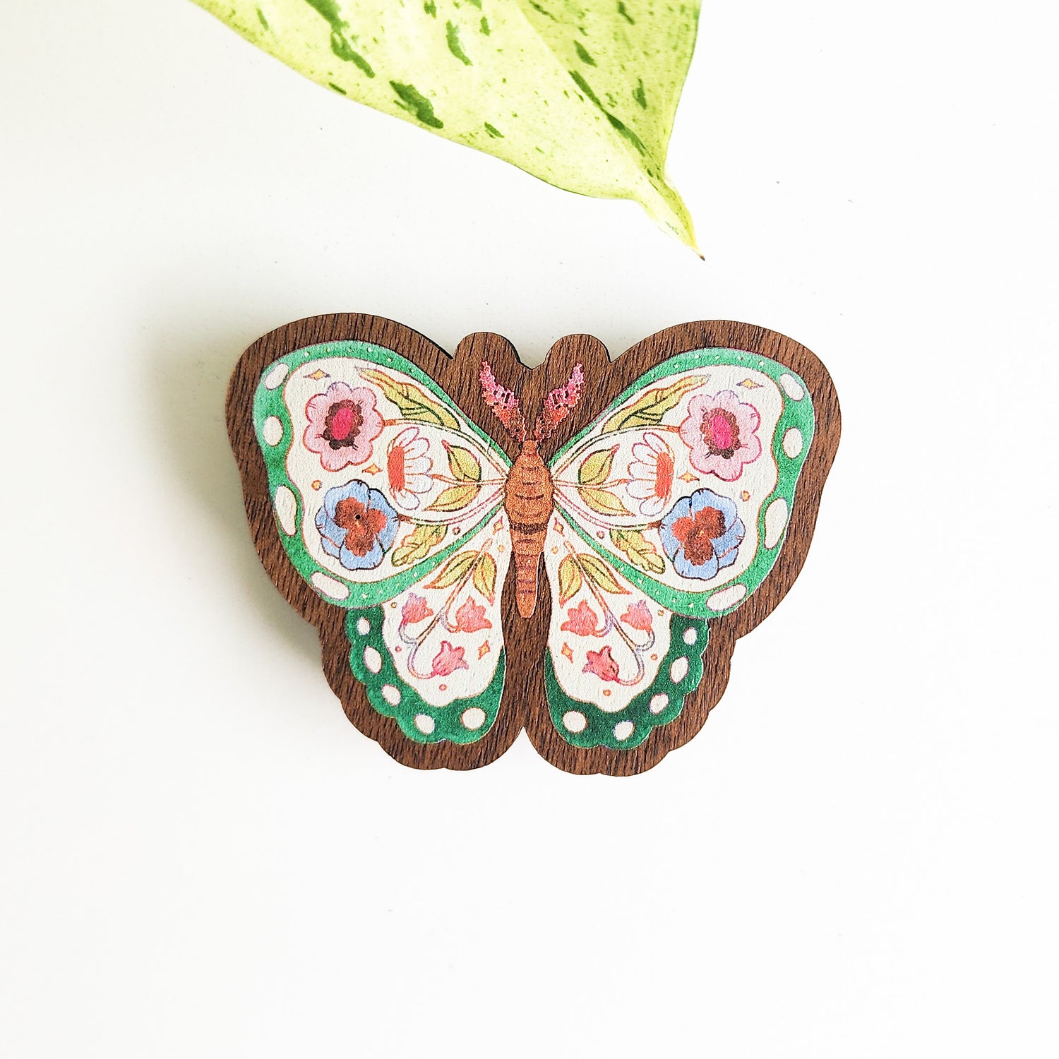 floral butterfly magnet on a white background with a leaf