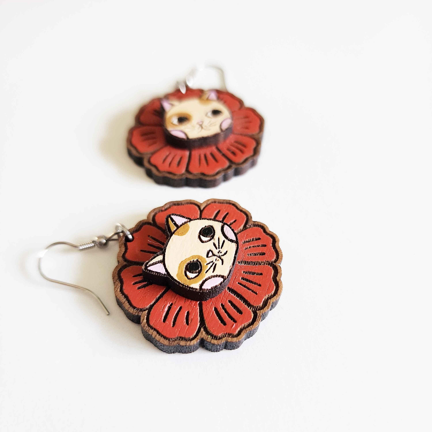 red flower earrings with a cat face in the center