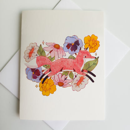 greeting card with an illustrated image of a fox leaping through flowers