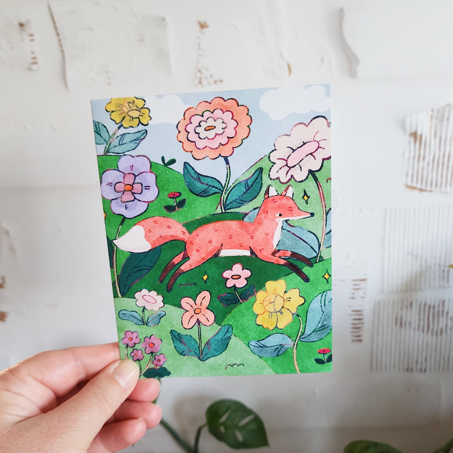 greeting card with a fox illustration held in a hand
