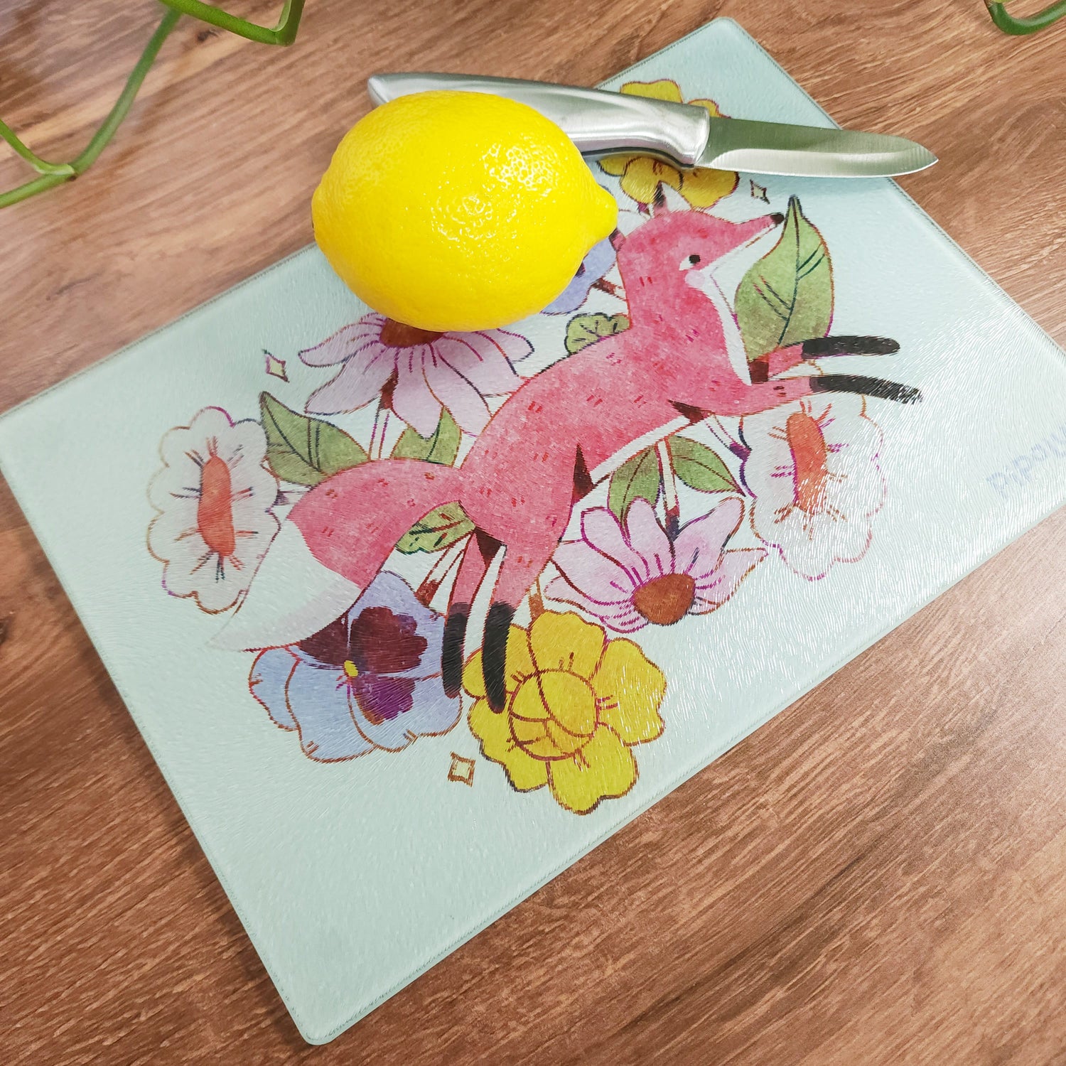 floral fox cutting board with a lemon and knife