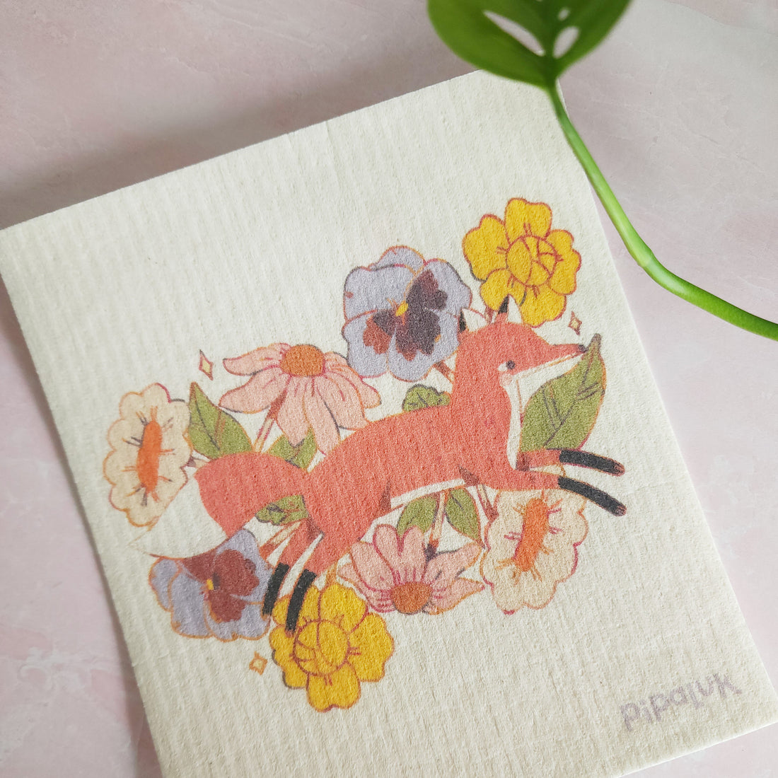 fox in blooms dishcloth laying against a pink background