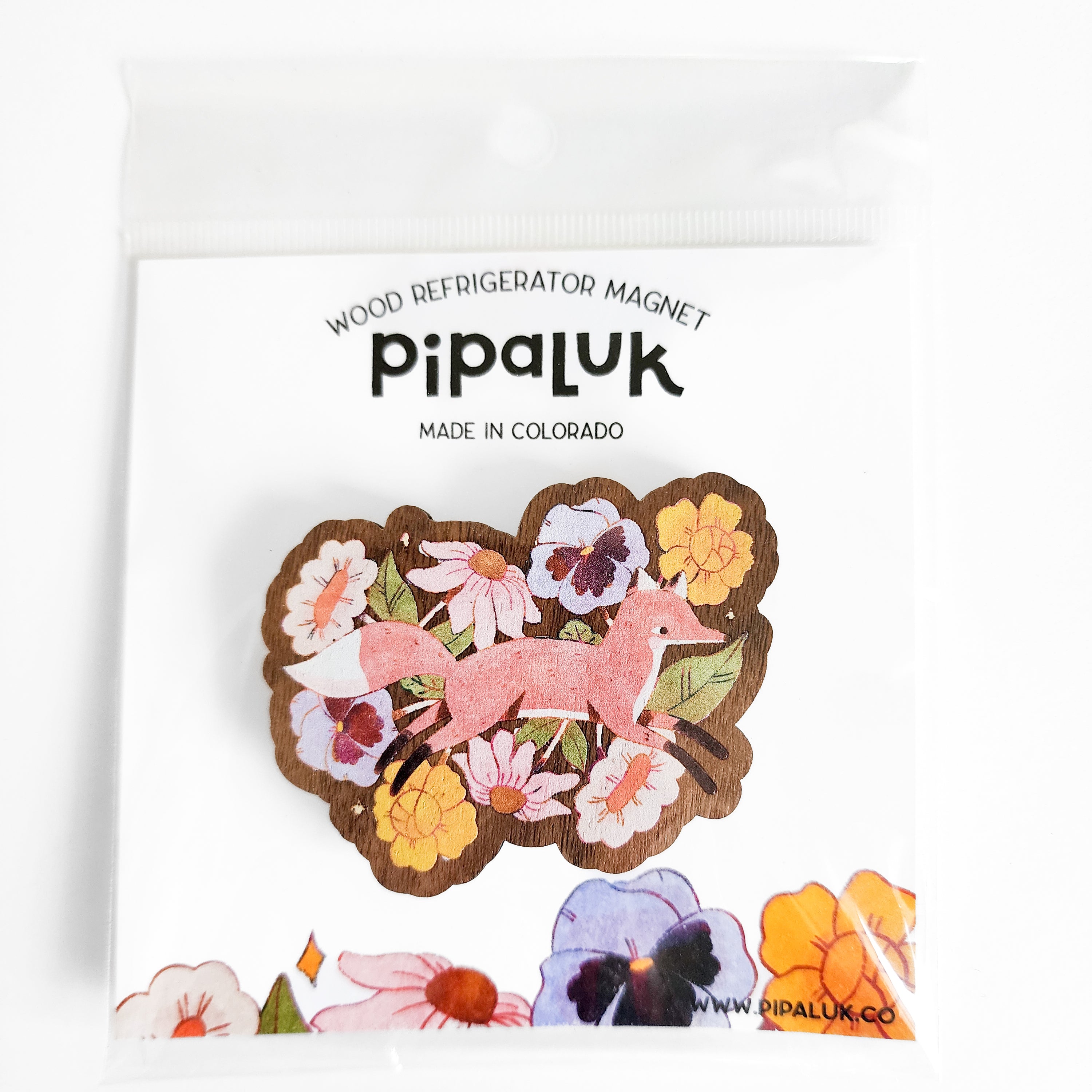Wooden refrigerator magnet with a fox and floral design on a white background, inside branded &