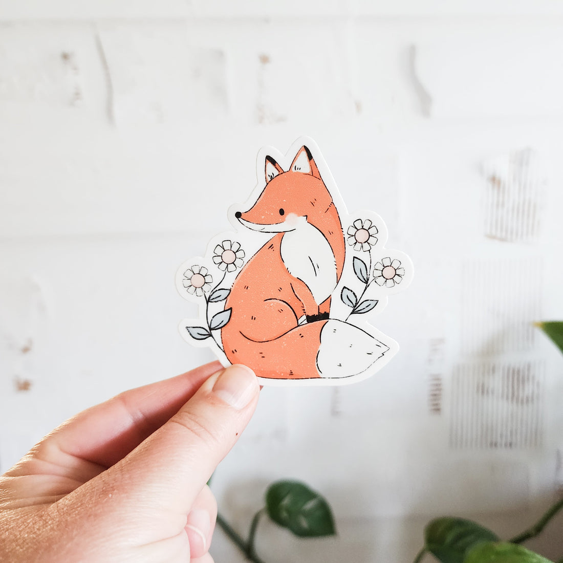 floral fox sticker held in a hand