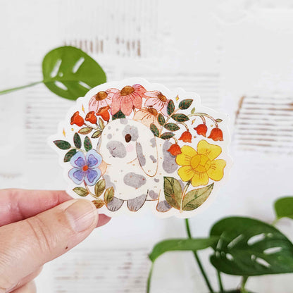 sticker of a gray and white rabbit in a garden of flowers