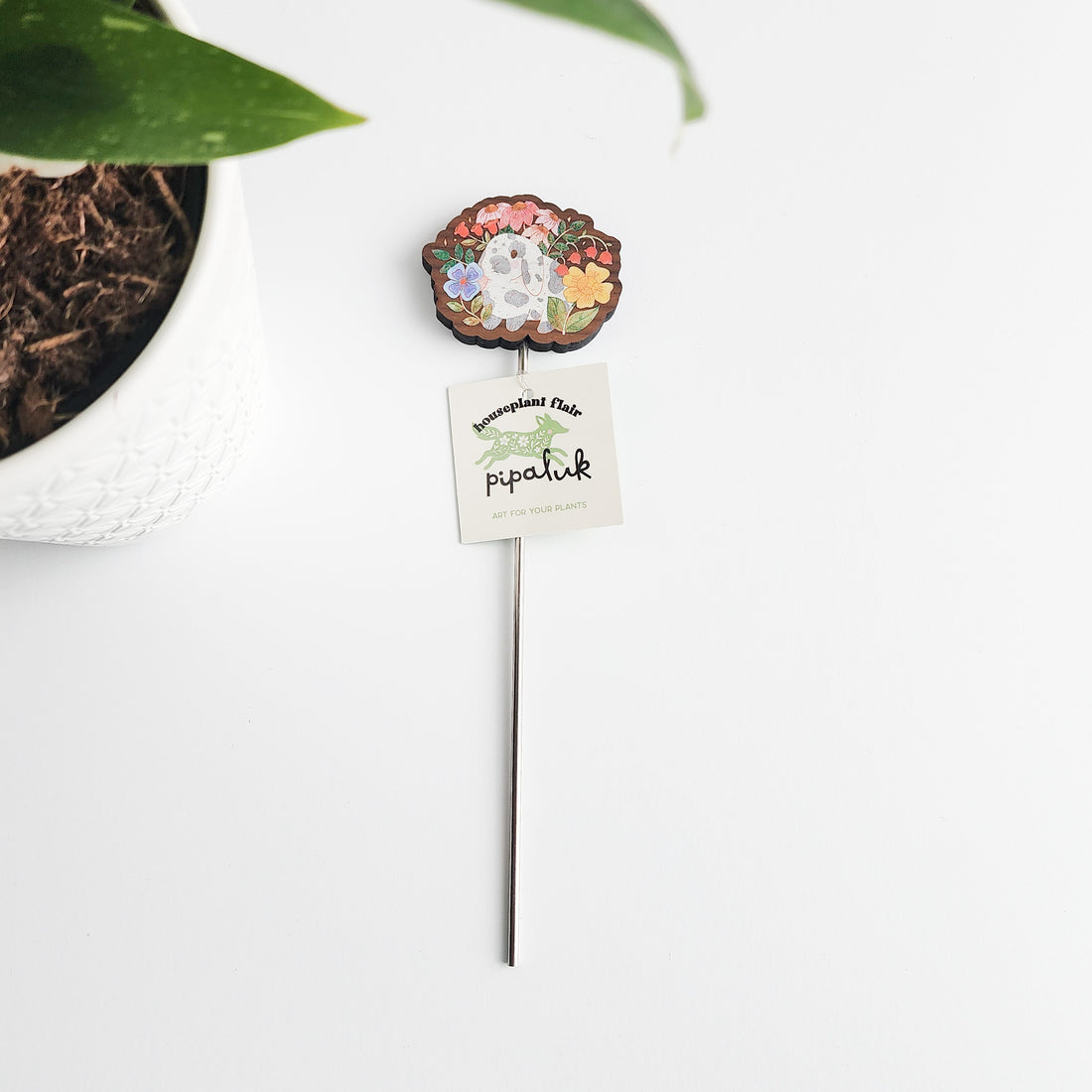 decorative floral bunny plant pick with a pipaluk label on a white background
