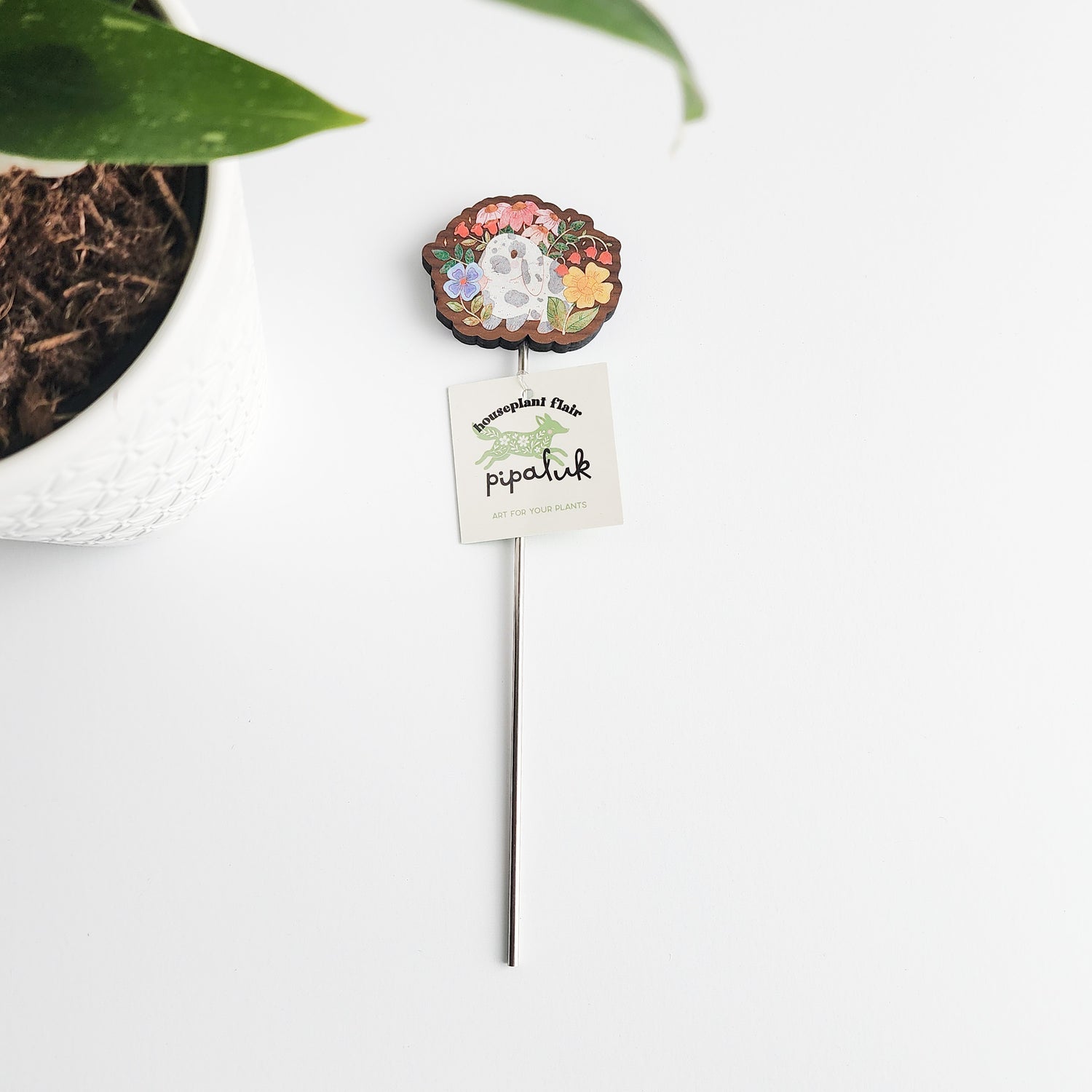 decorative floral bunny plant pick with a pipaluk label on a white background